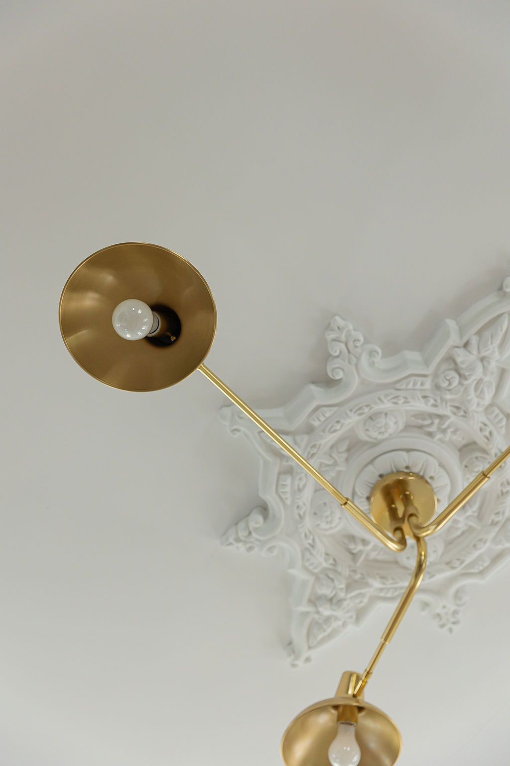 Elegant gold and clear crystal chandelier with snowflake design shown in close-up detail against a white ceiling.