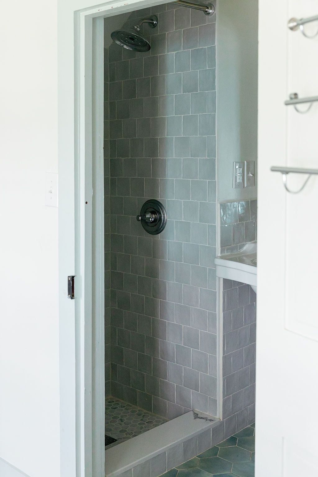 Modern gray subway tile walk-in shower with white trim and glass door features sleek minimalist design.