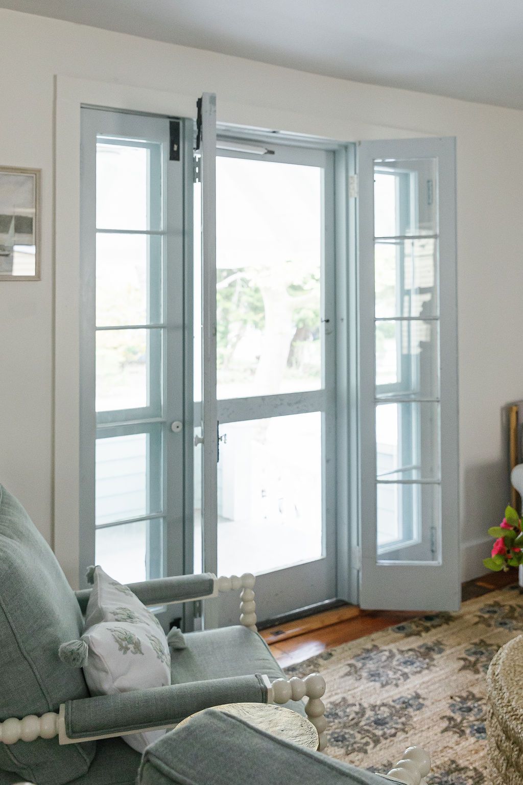 Four connected photos showing a bright sunlit room with white windows, light blue curtains, and a floral area rug.