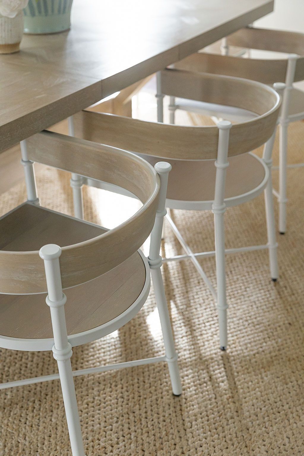 Chunky oversized coffee table letter decor spelling out 'gather' on a beige jute rug.