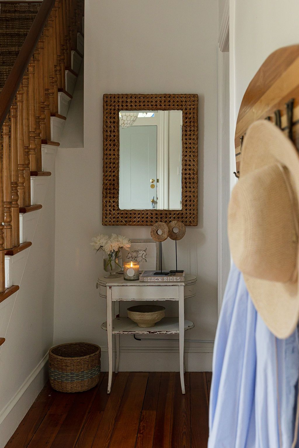 Rustic bathroom with wooden staircase features multiple mirrors, a vessel sink, and hardwood flooring in neutral tones.