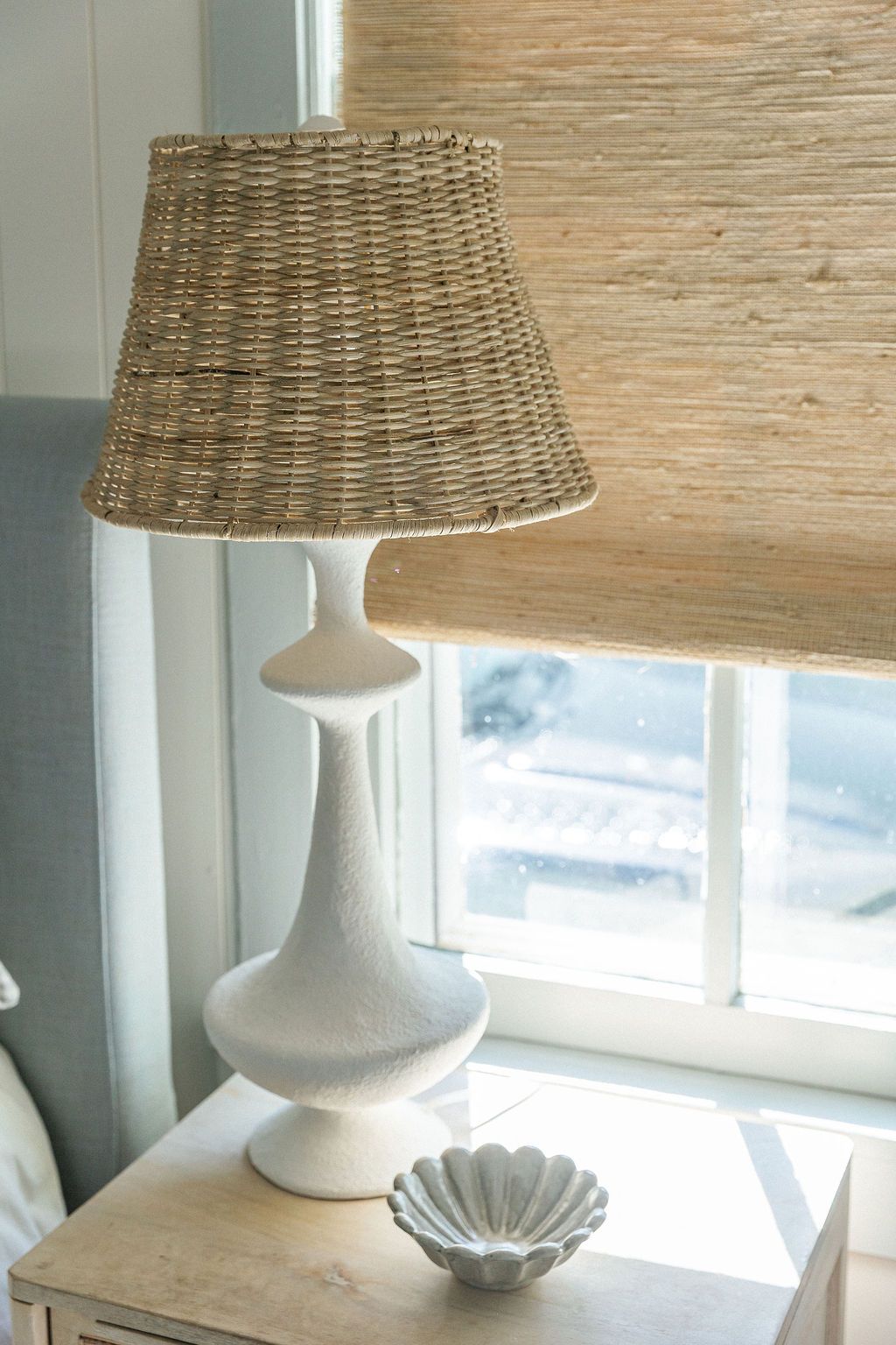 DIY tutorial showing the transformation of a table lamp with a woven basket shade in a bright coastal-style room.