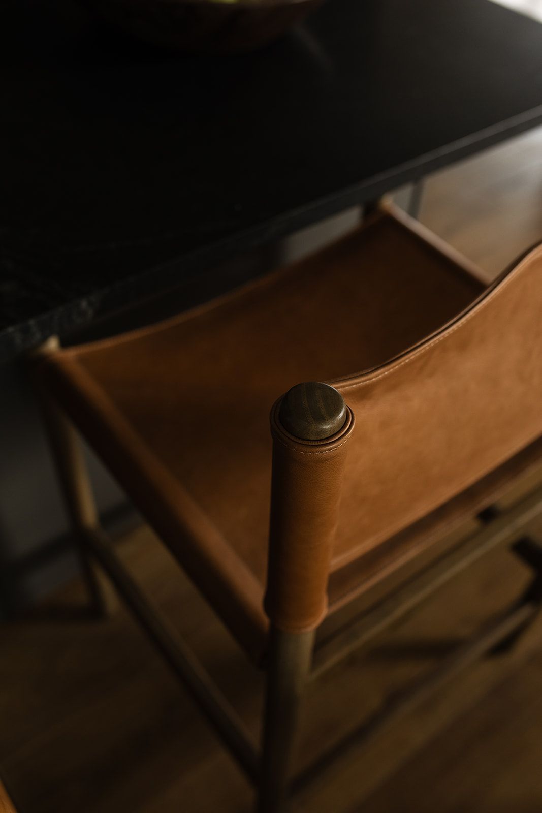 Close-up detail of tan leather furniture against a dark background.