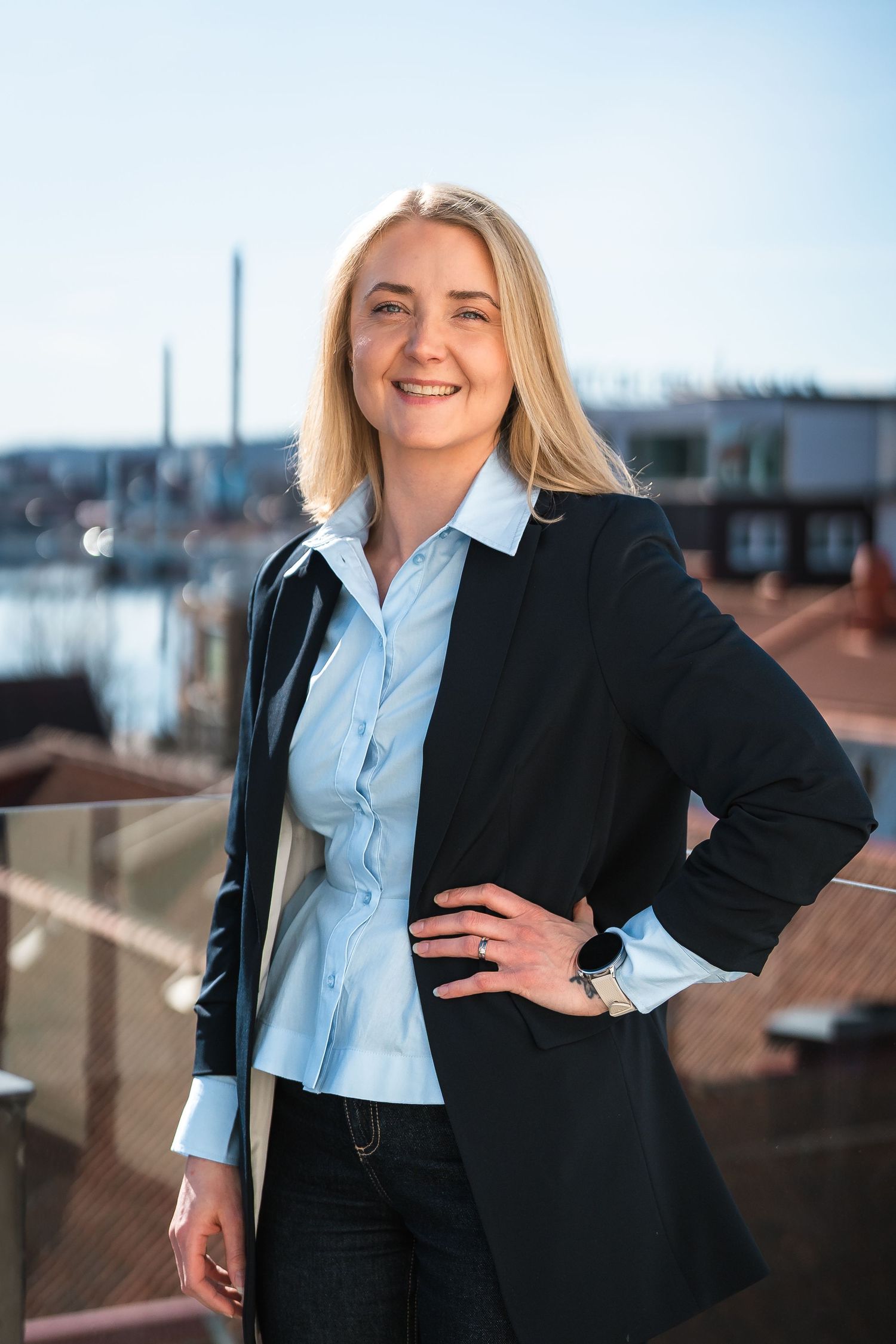 Leende porträtt av kvinna utomhus vid vatten.