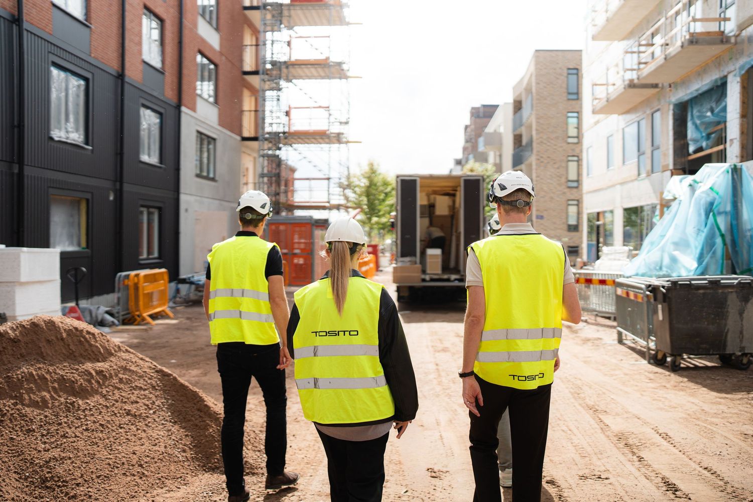 Byggteam i varselvästar på en arbetsplats.