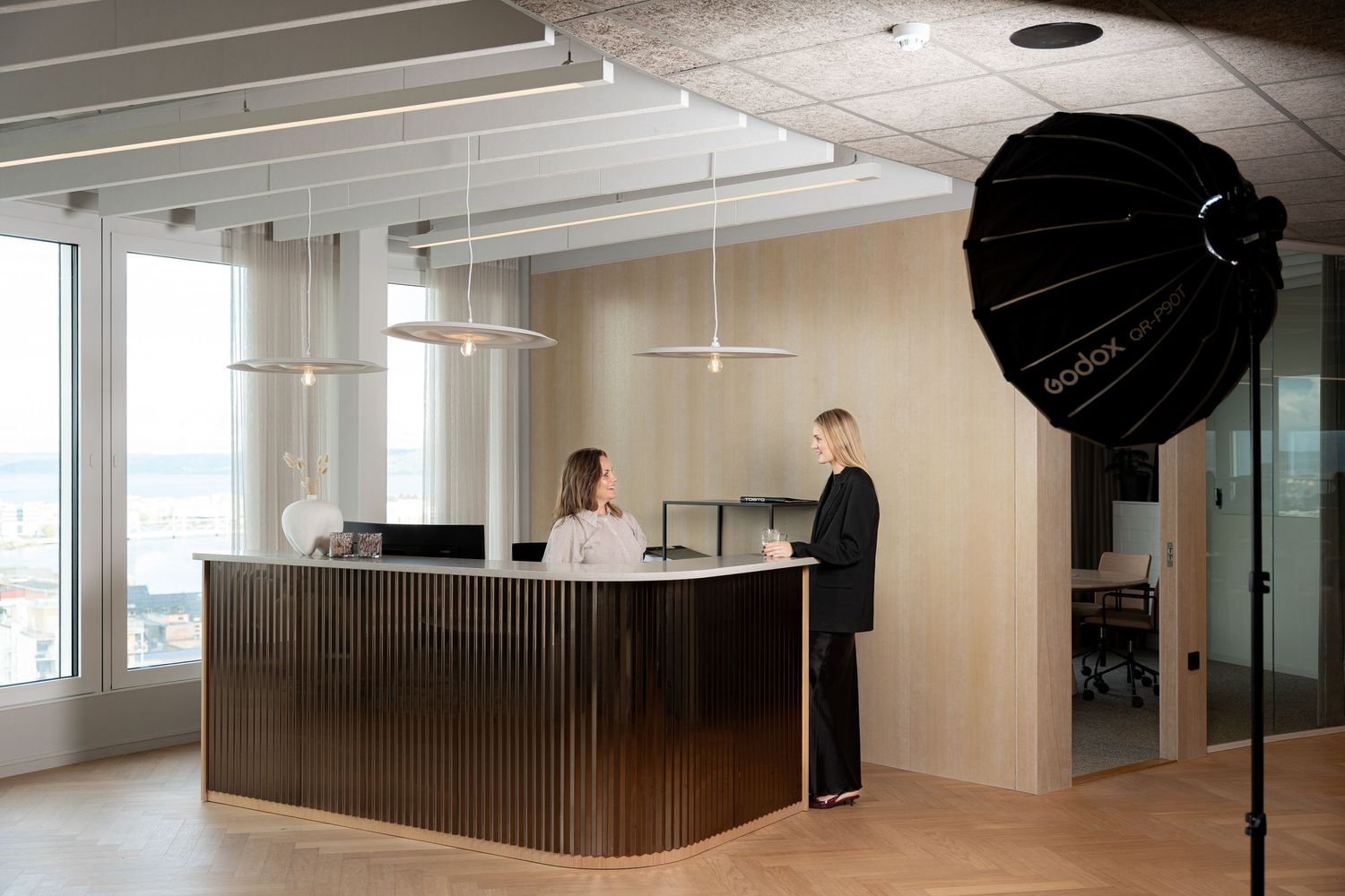 Fotouppställning i modern kontorsmiljö med träpaneler.