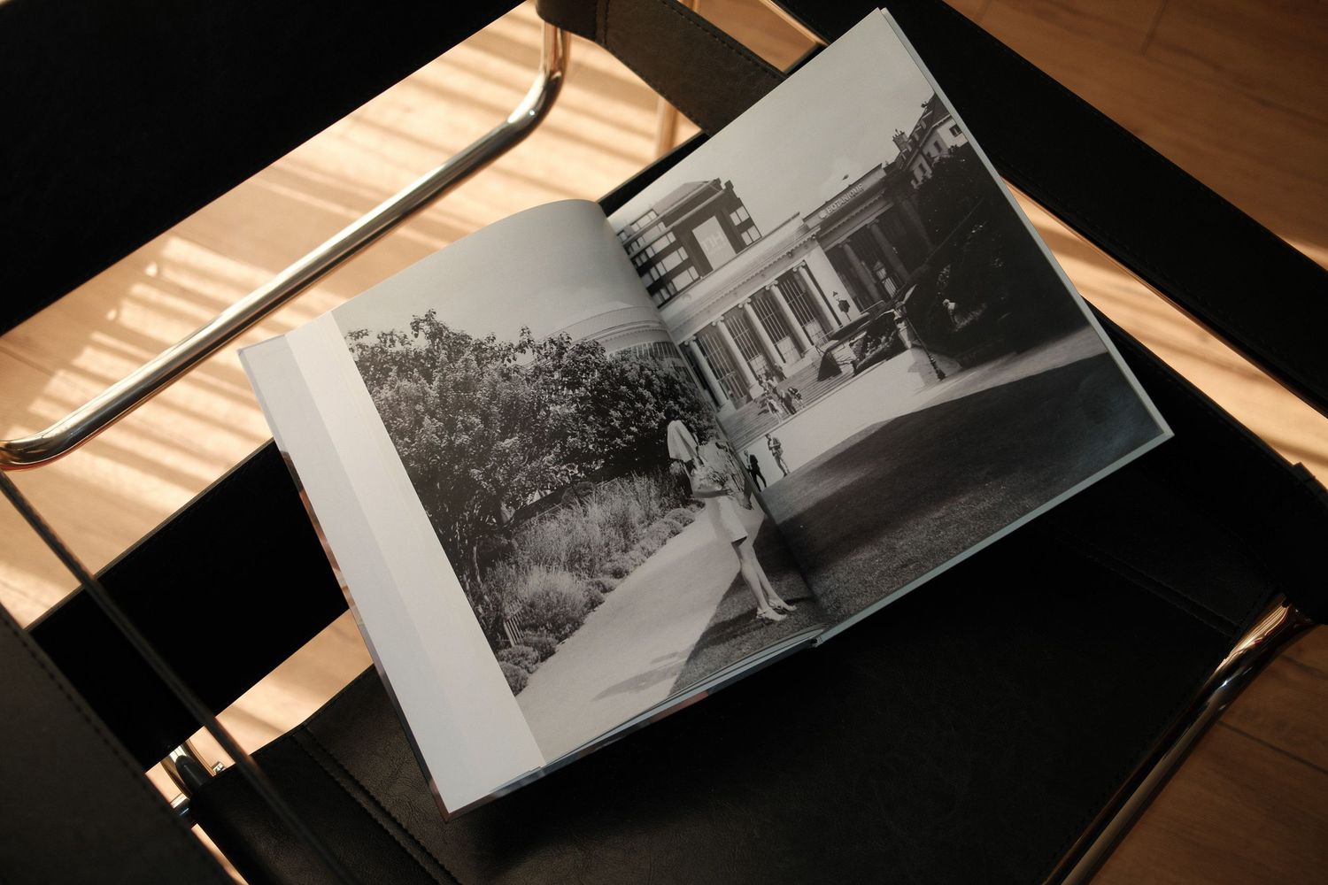 Black and white photographs are arranged on a wooden surface showing vintage street and architectural scenes.