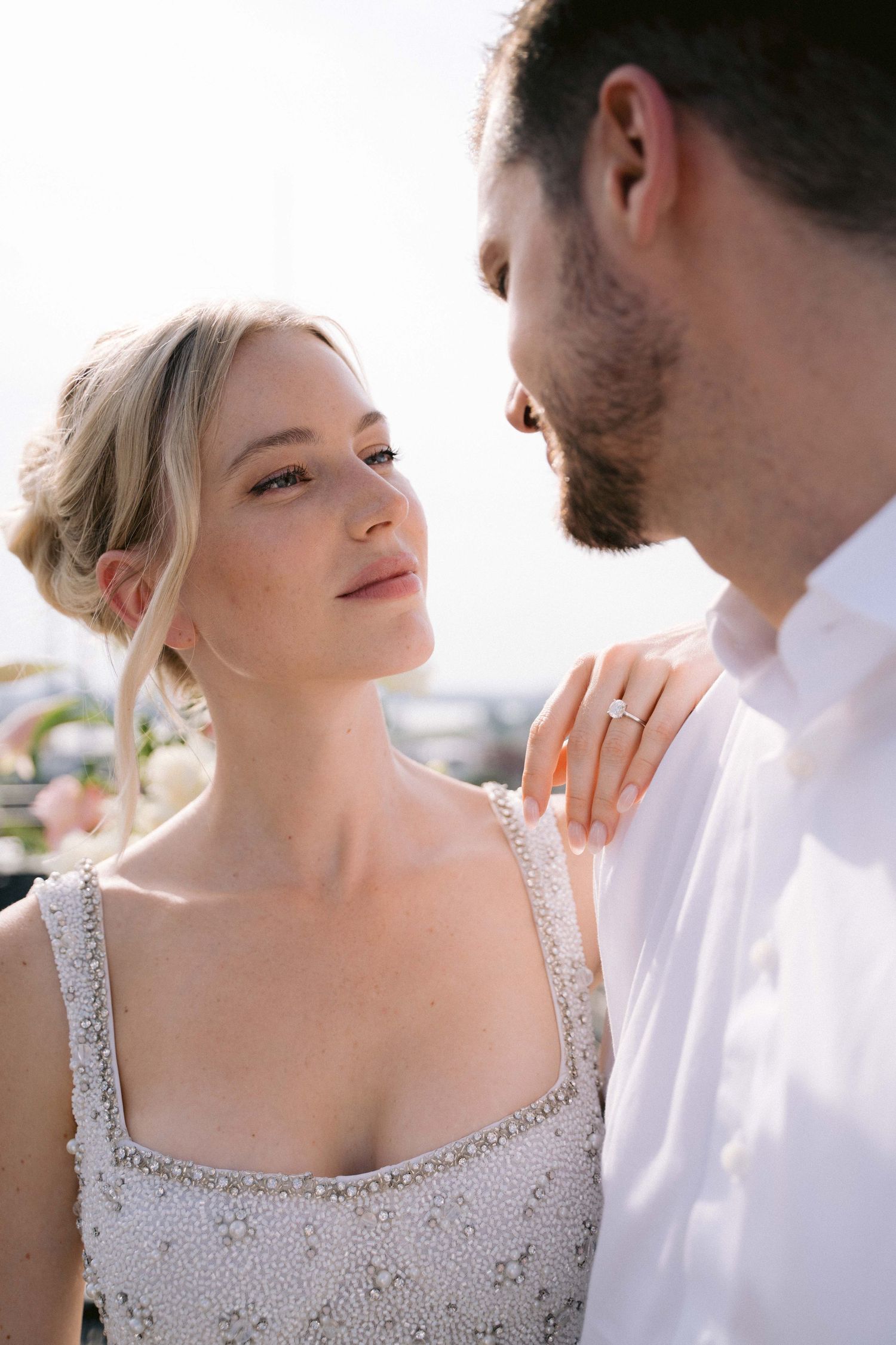 Intimate moment between couple in formal wear against blurred background.