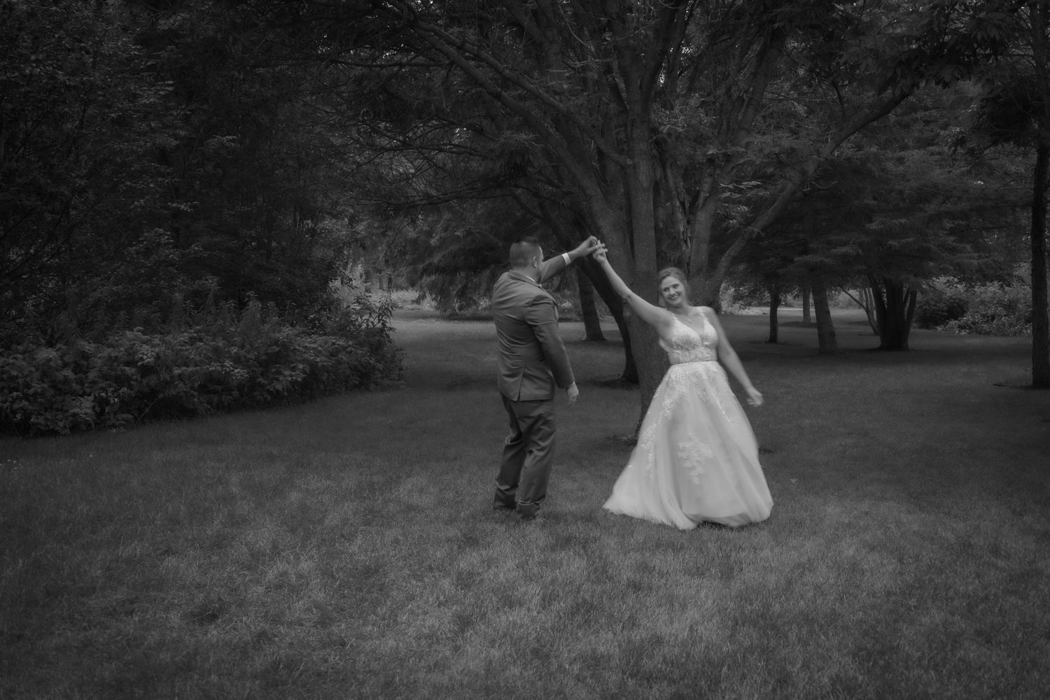 A romantic dance captured in black and white on a garden lawn.