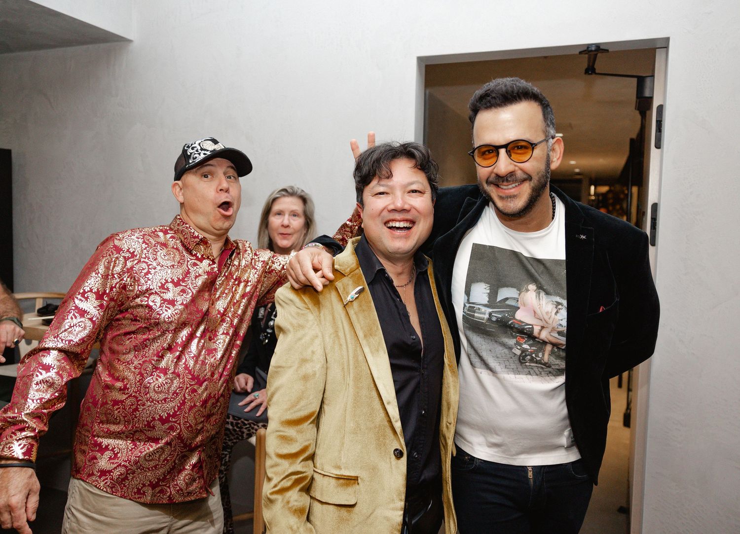 A group of people enjoying a social gathering wearing casual and formal attire including a shiny red jacket.