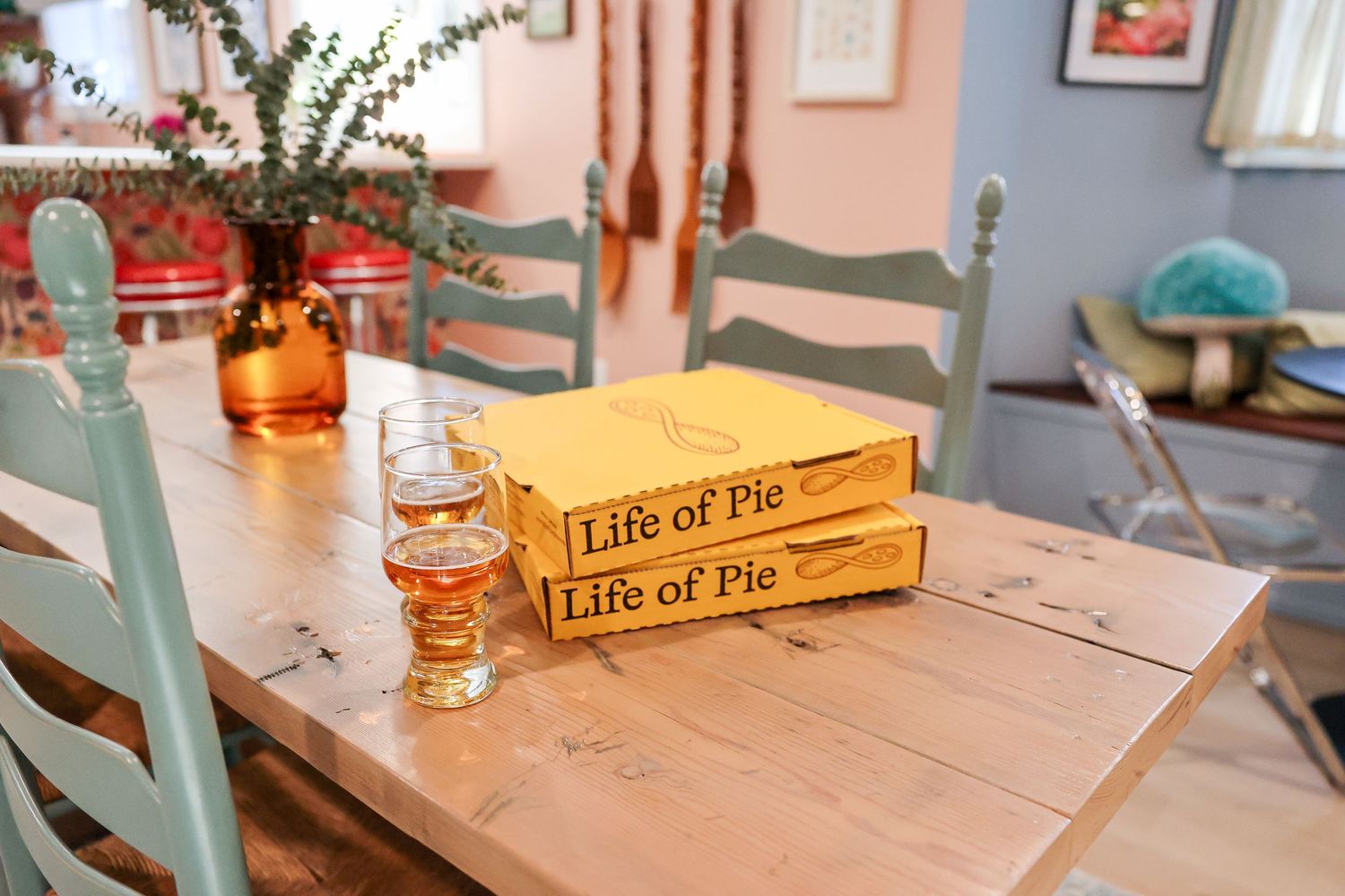 Wooden table with vintage board games and amber glass vase centerpiece.