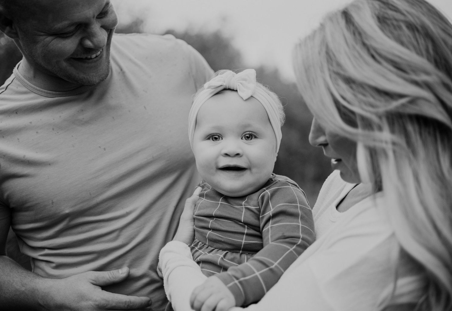 Black and white candid family portrait with joyful expressions.