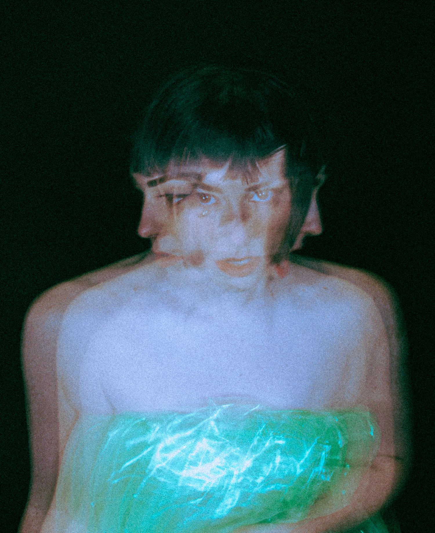 A series of dark photographs showing a glowing turquoise light effect against a black background.