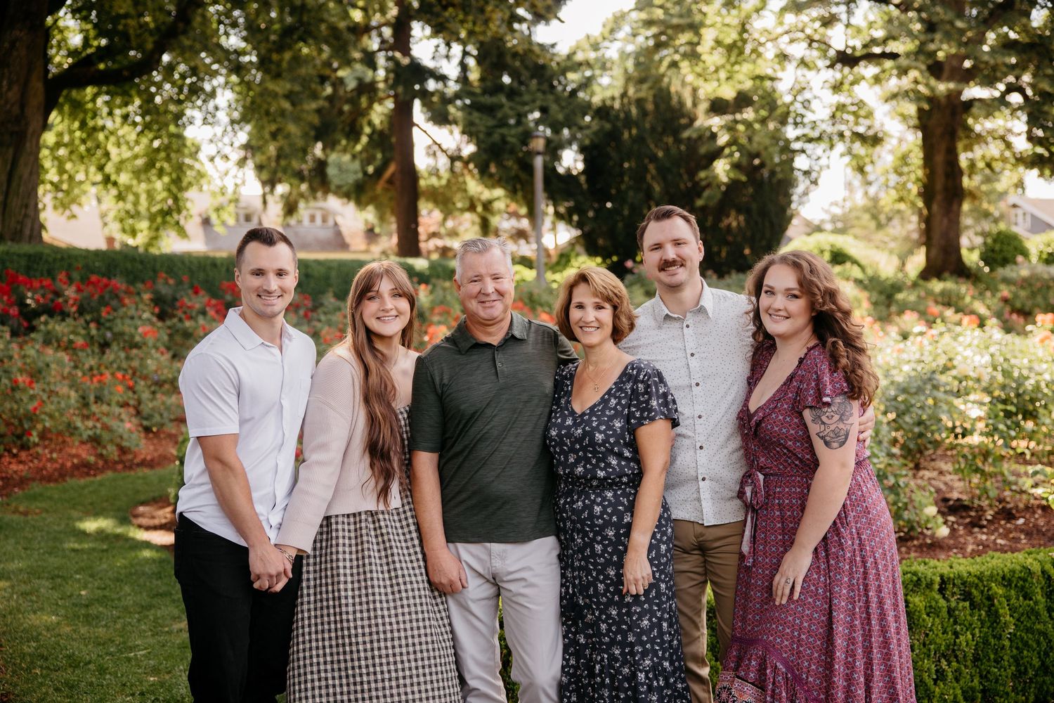 A series of coordinated outdoor family portraits taken in a garden setting at golden hour with matching color schemes.