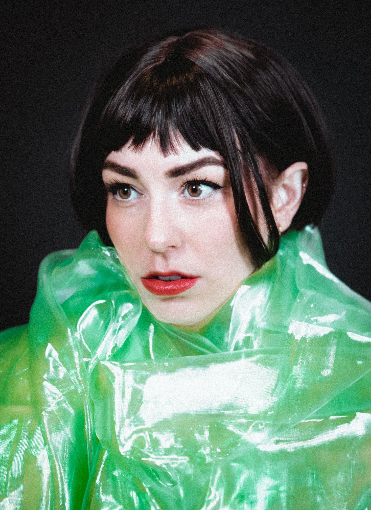 A portrait series showing a figure wrapped in translucent green plastic material creating an ethereal artistic effect.