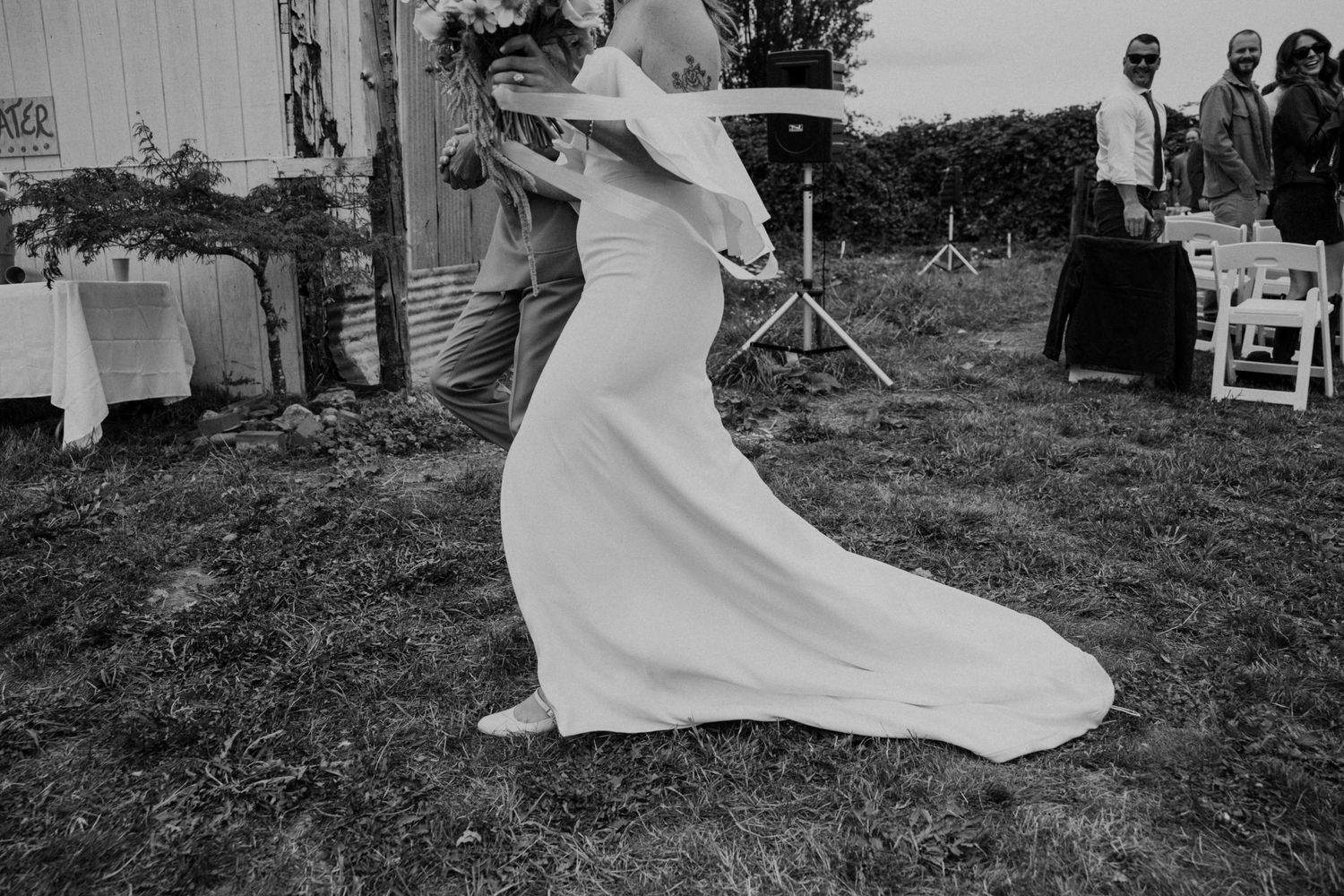 A black and white photo captures the flowing movement of a wedding dress during a dance.