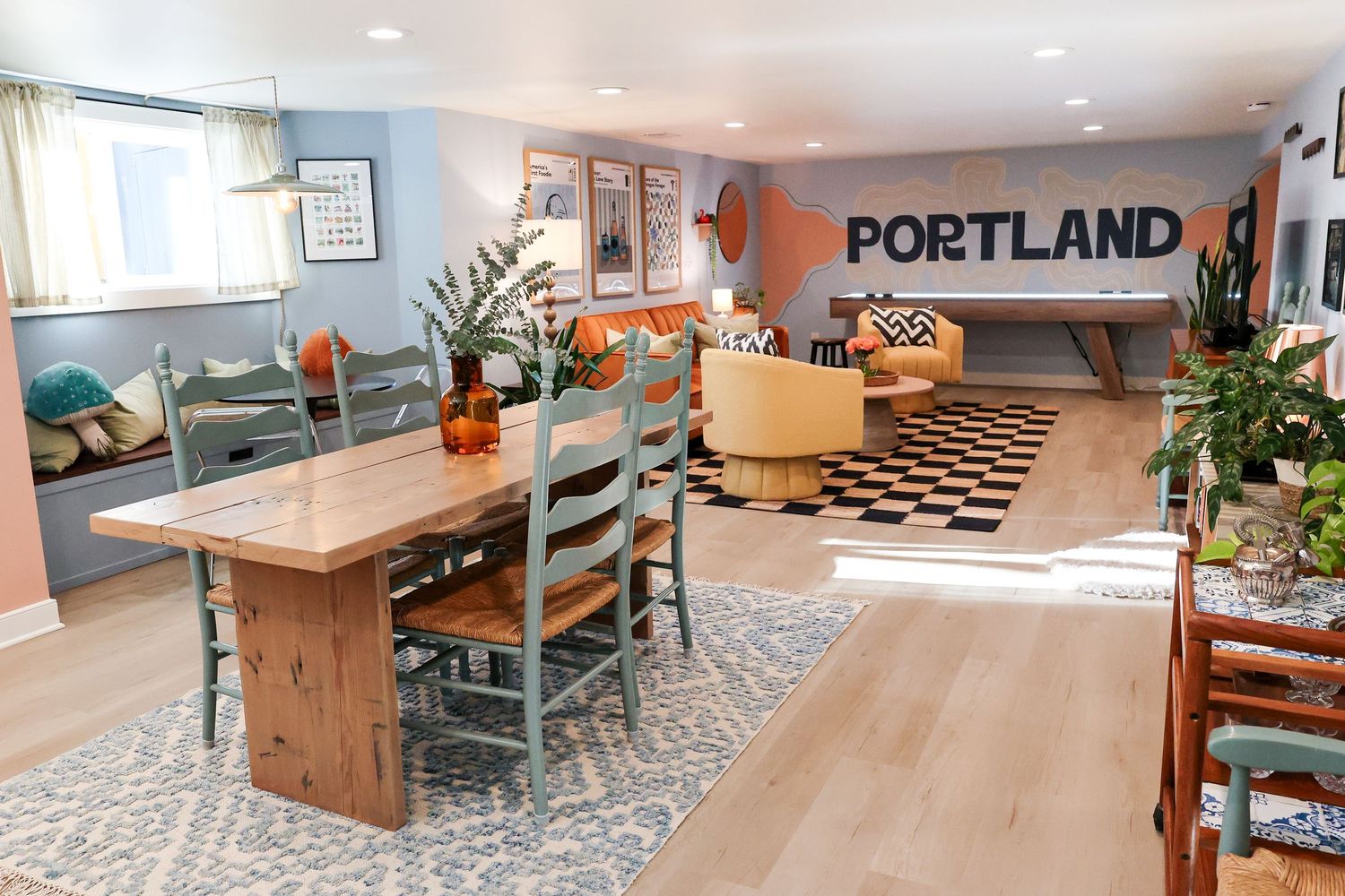 Modern basement recreation room with Portland sign and mixed seating arrangements.