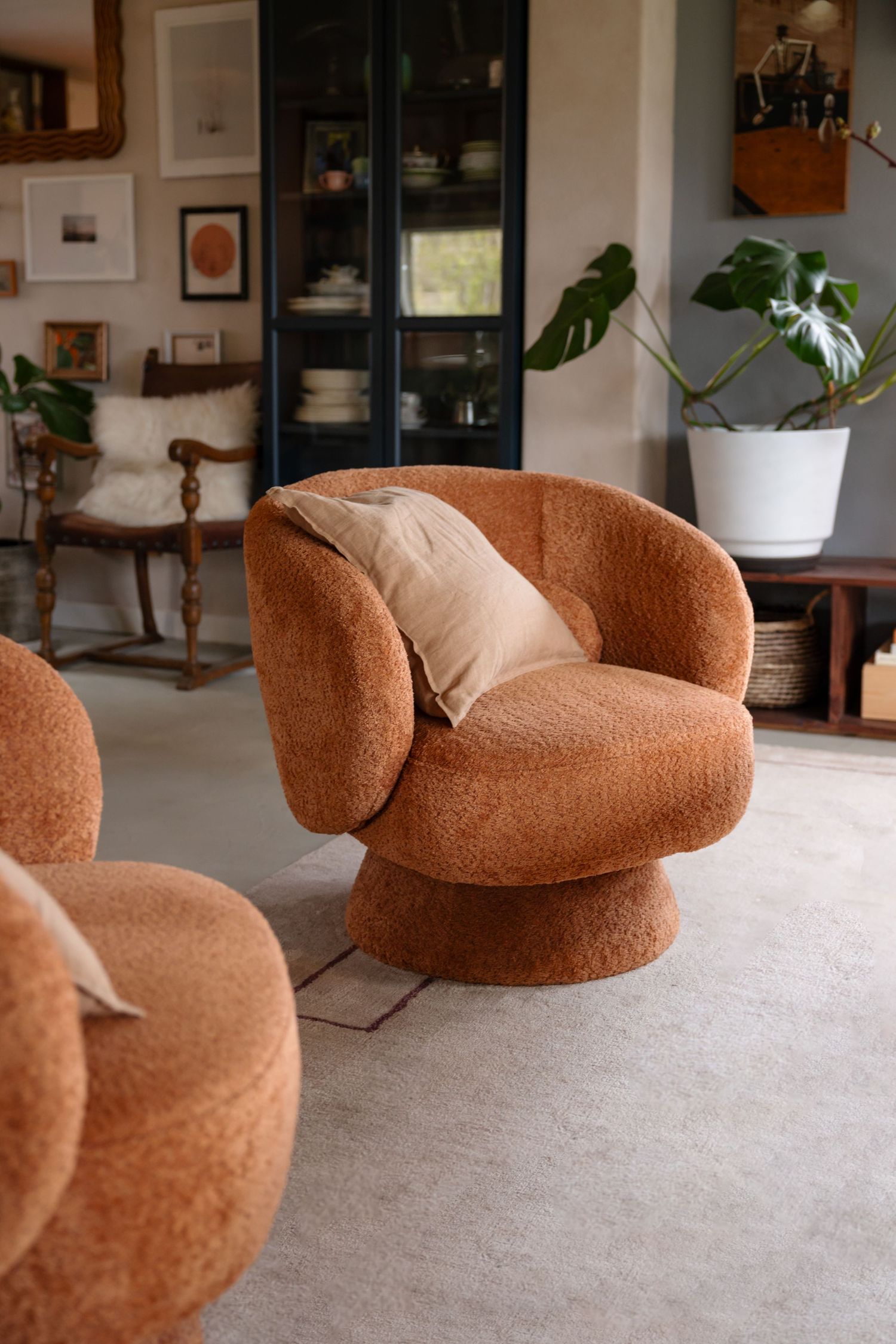 Modern curved teddy fabric swivel chair in terracotta color with plush upholstery.