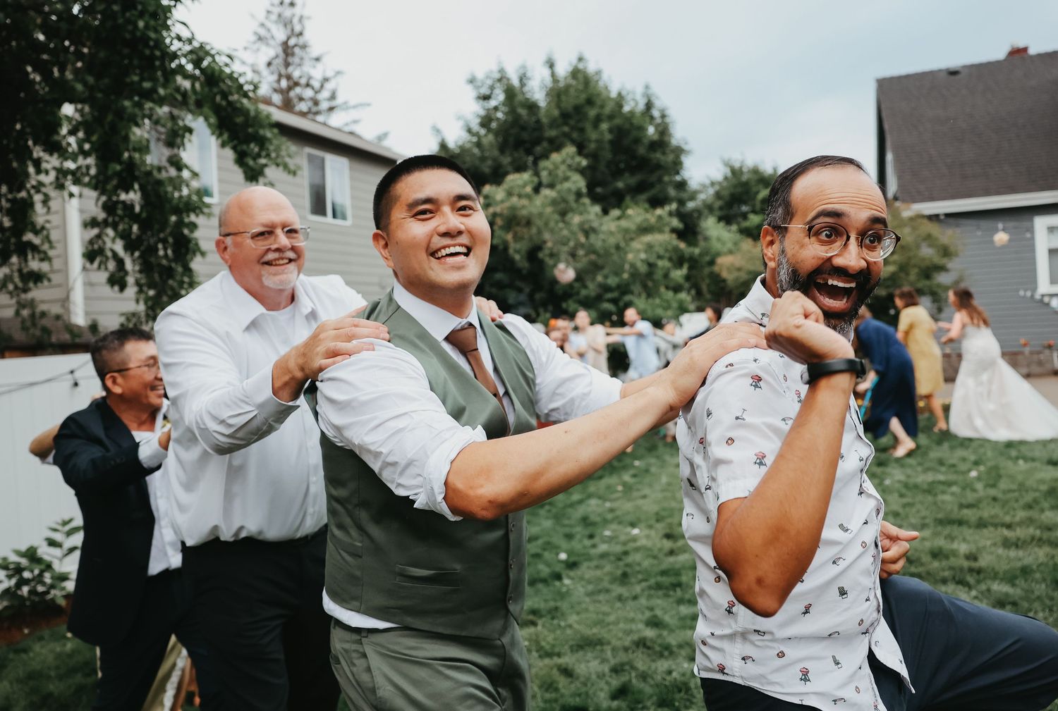 Wedding guests dancing and celebrating with enthusiasm at an outdoor reception.