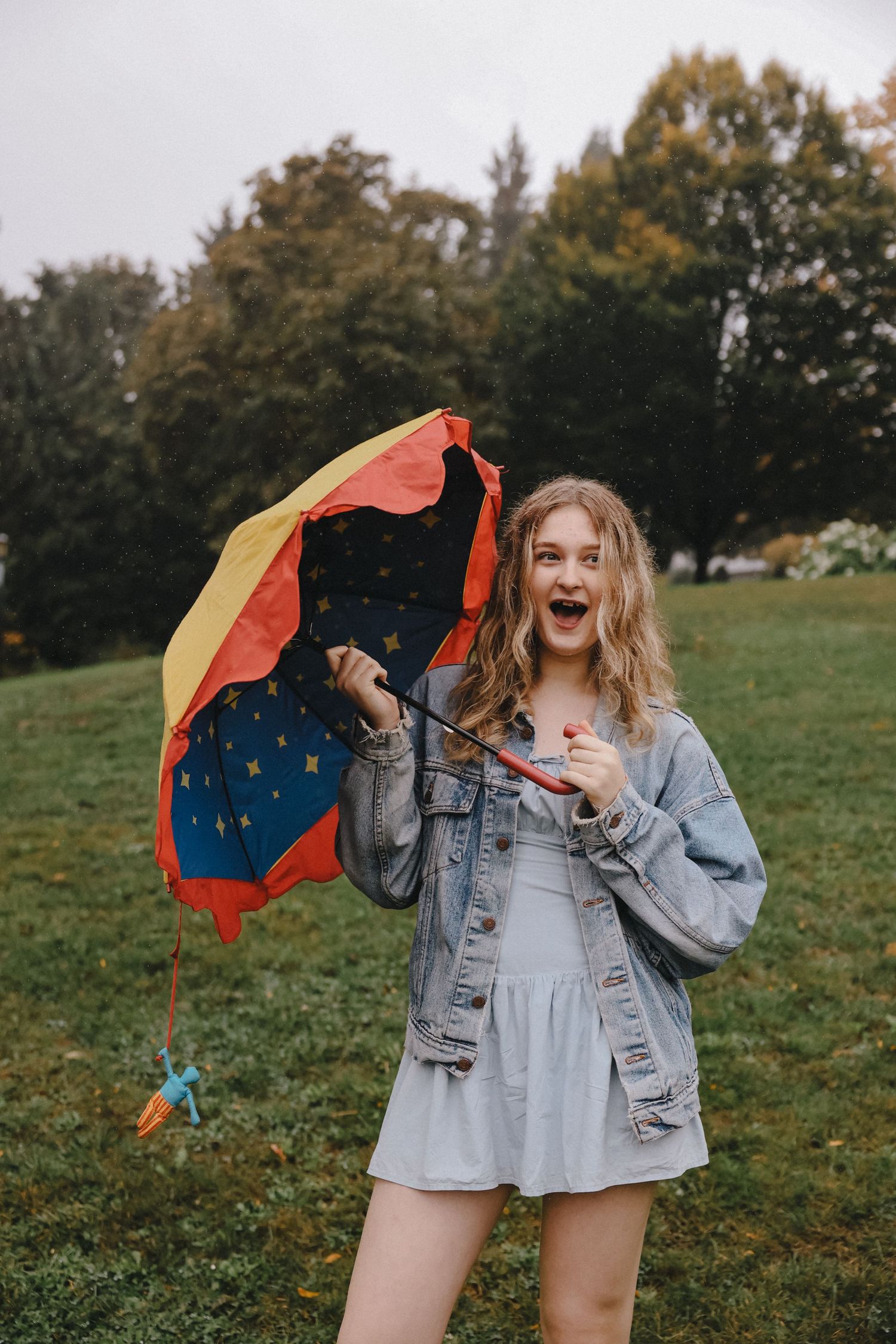 Playful outdoor portrait with colorful scarf against autumn landscape.