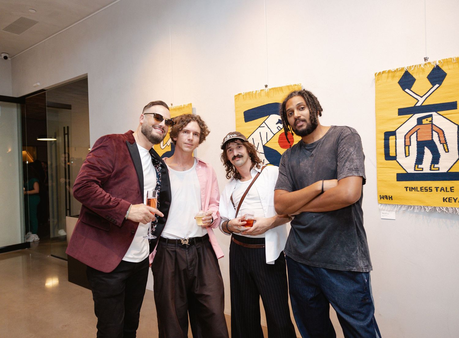 Gallery attendees interact and view colorful artwork mounted on walls during an exhibition event.