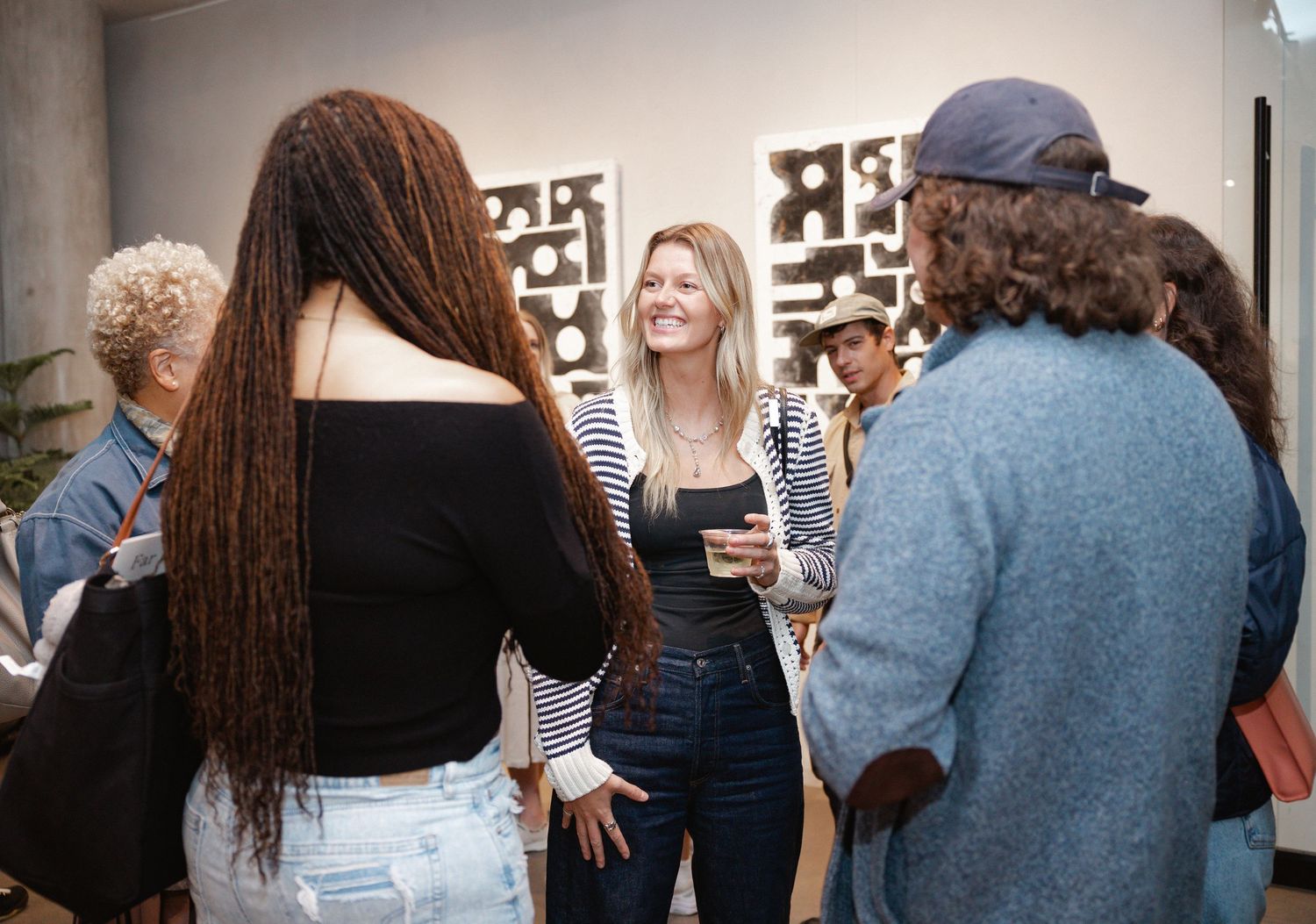A group of people standing together in a casual indoor gathering space.