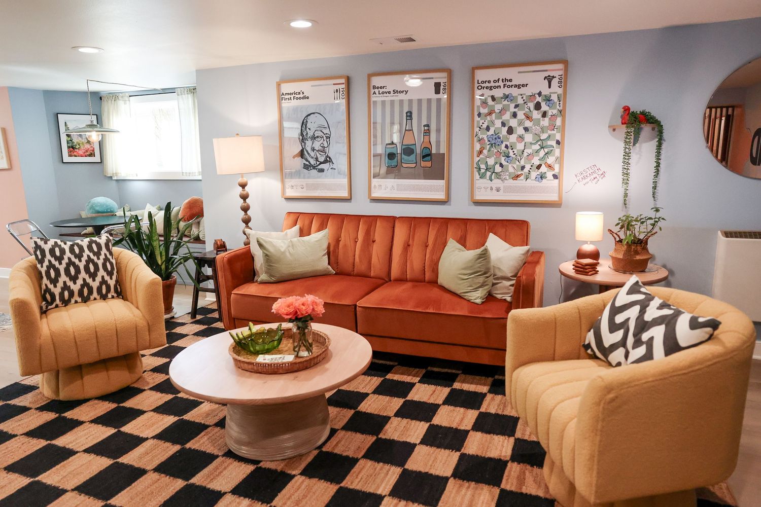 Retro-styled lounge area with orange couch, geometric patterns and decorative wall art.