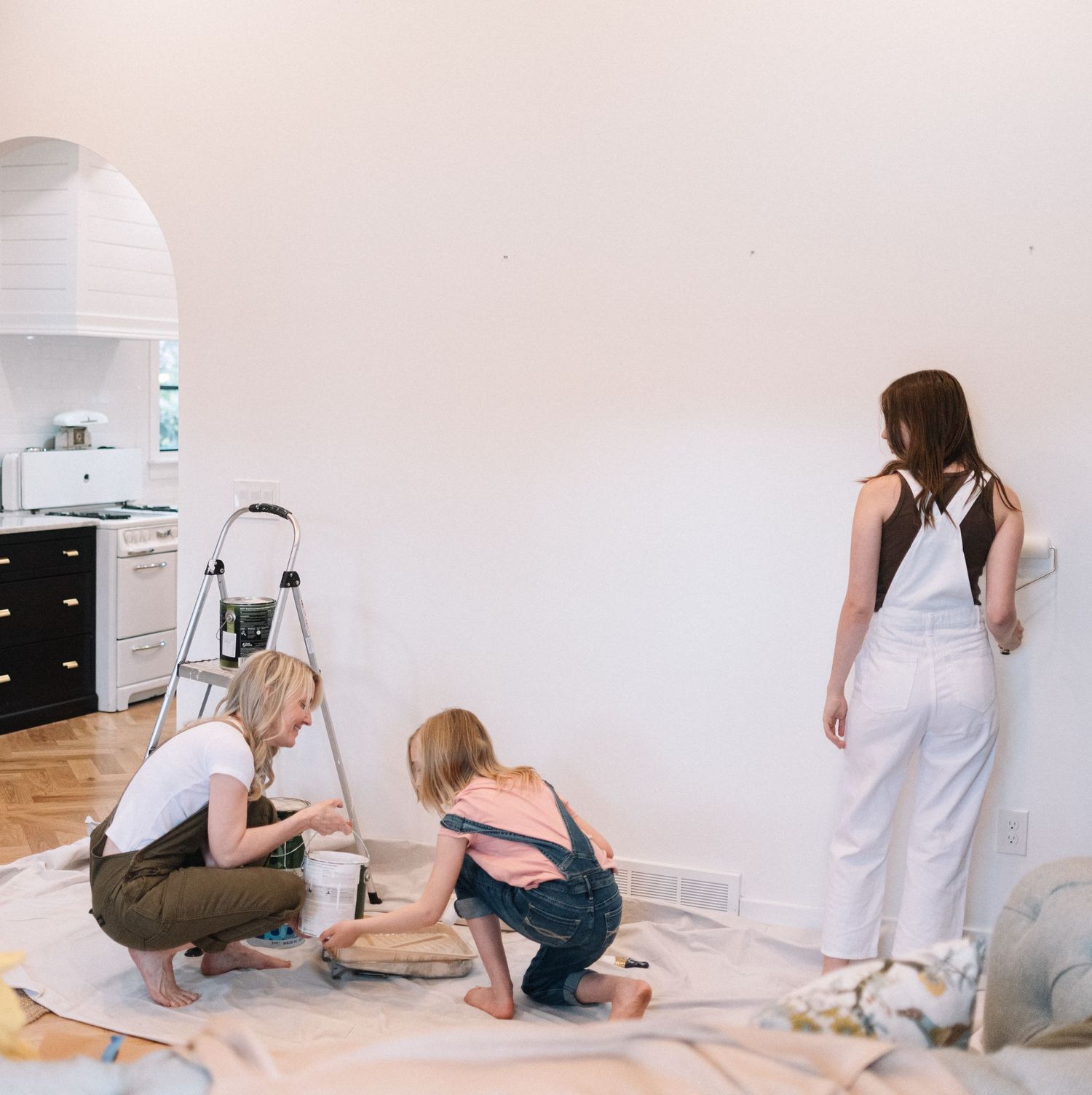 People working together on a floor project in a bright modern kitchen space.