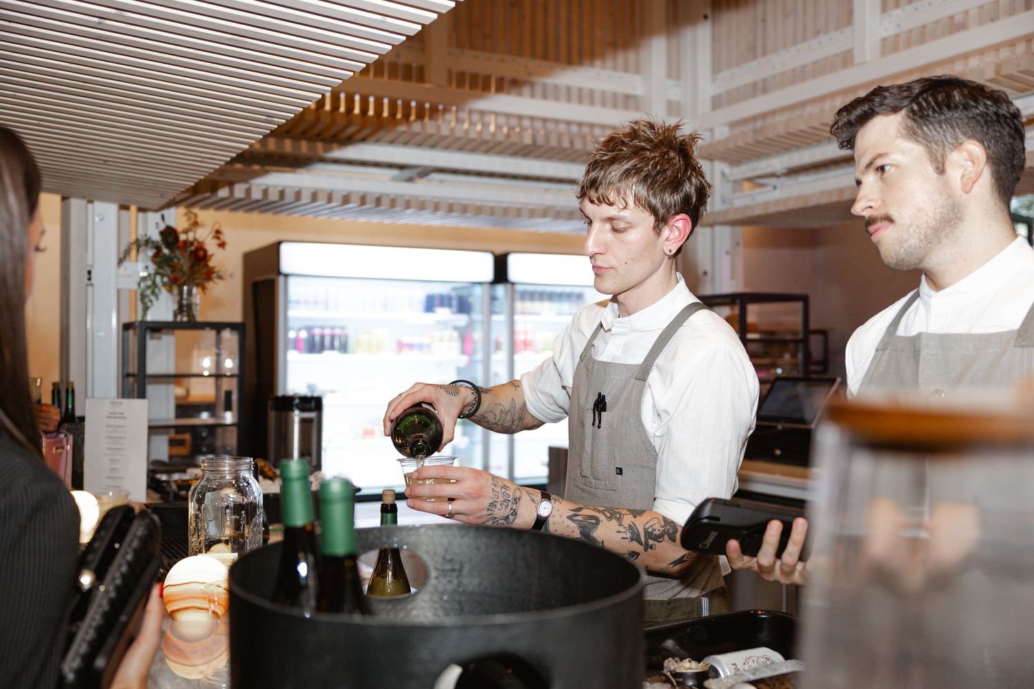Professional chefs in white uniforms work together in a modern restaurant kitchen preparing dishes.