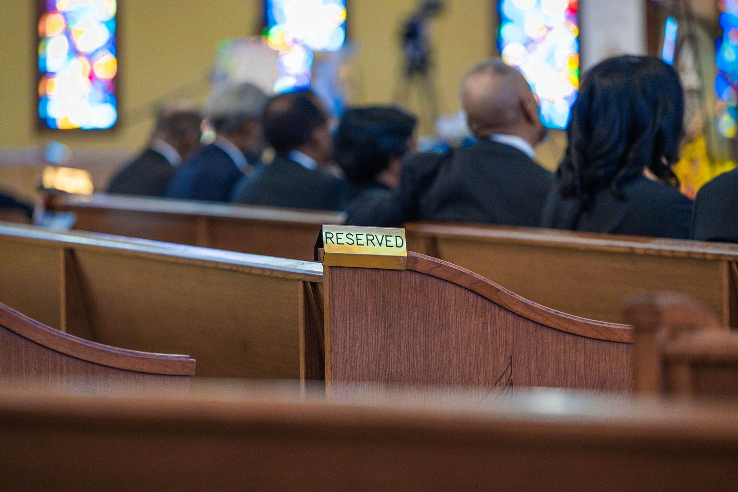Church interior with colorful stained glass windows and wooden pews.