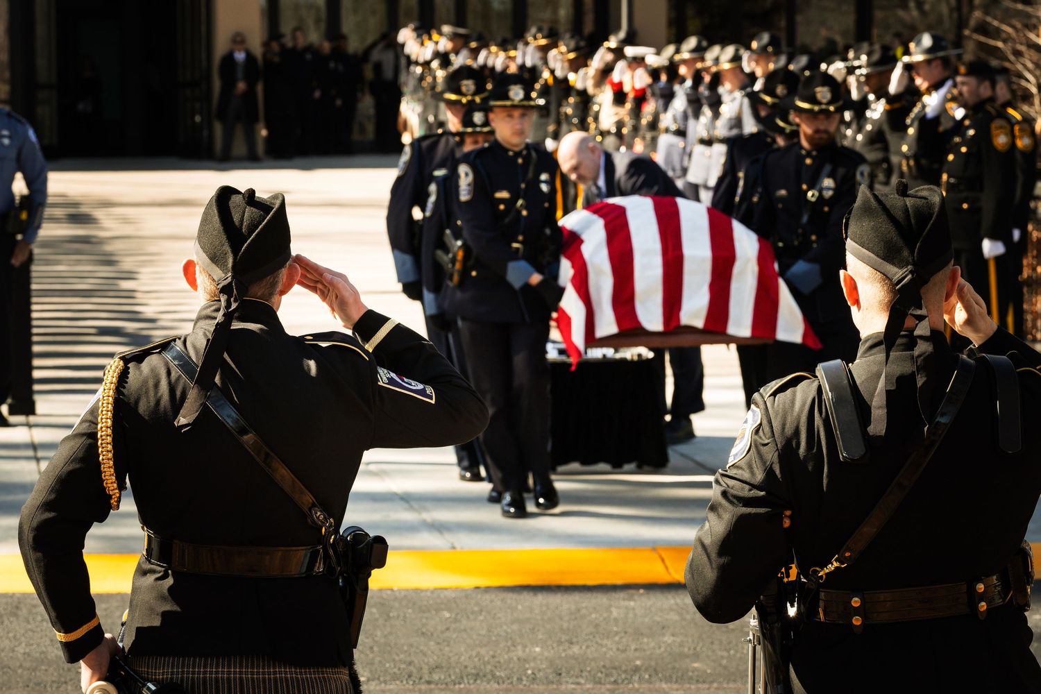 Honor guard members carry a flag-draped casket during a formal funeral procession ceremony.