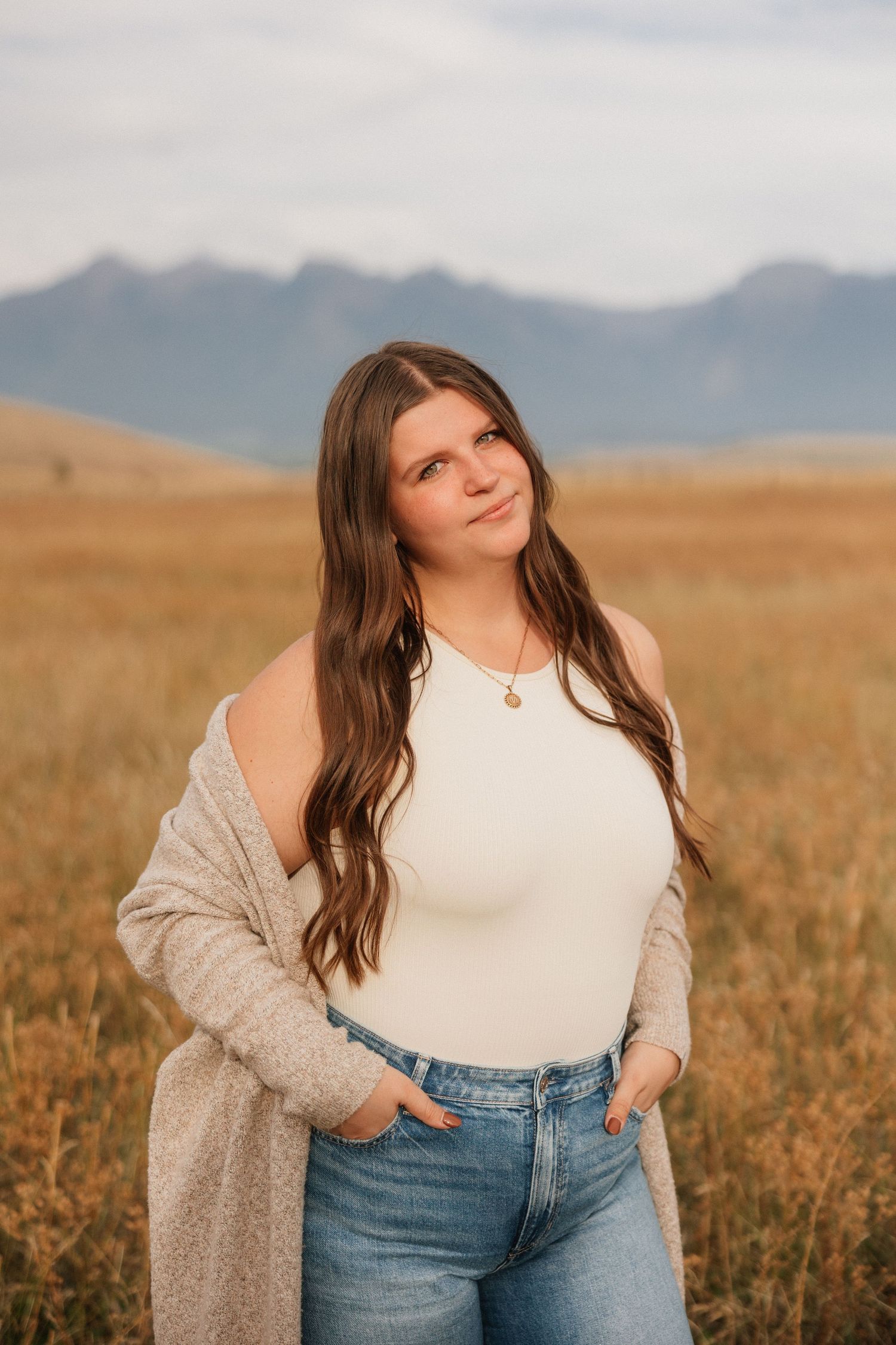 Outdoor portrait series in a field with mountains visible in the background.