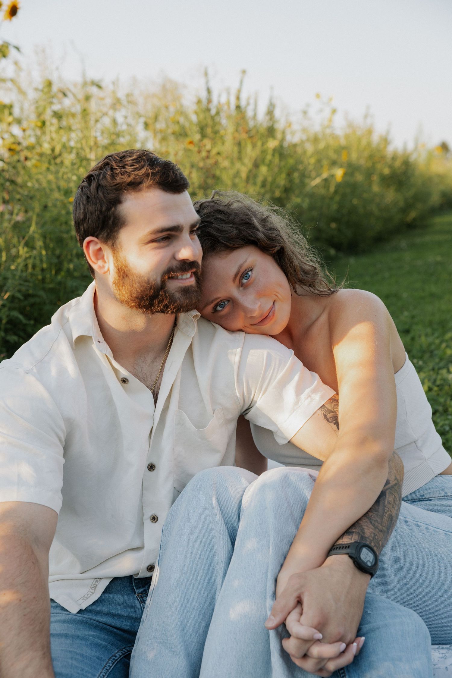 Couple sharing intimate moment while sitting together in golden sunlight.