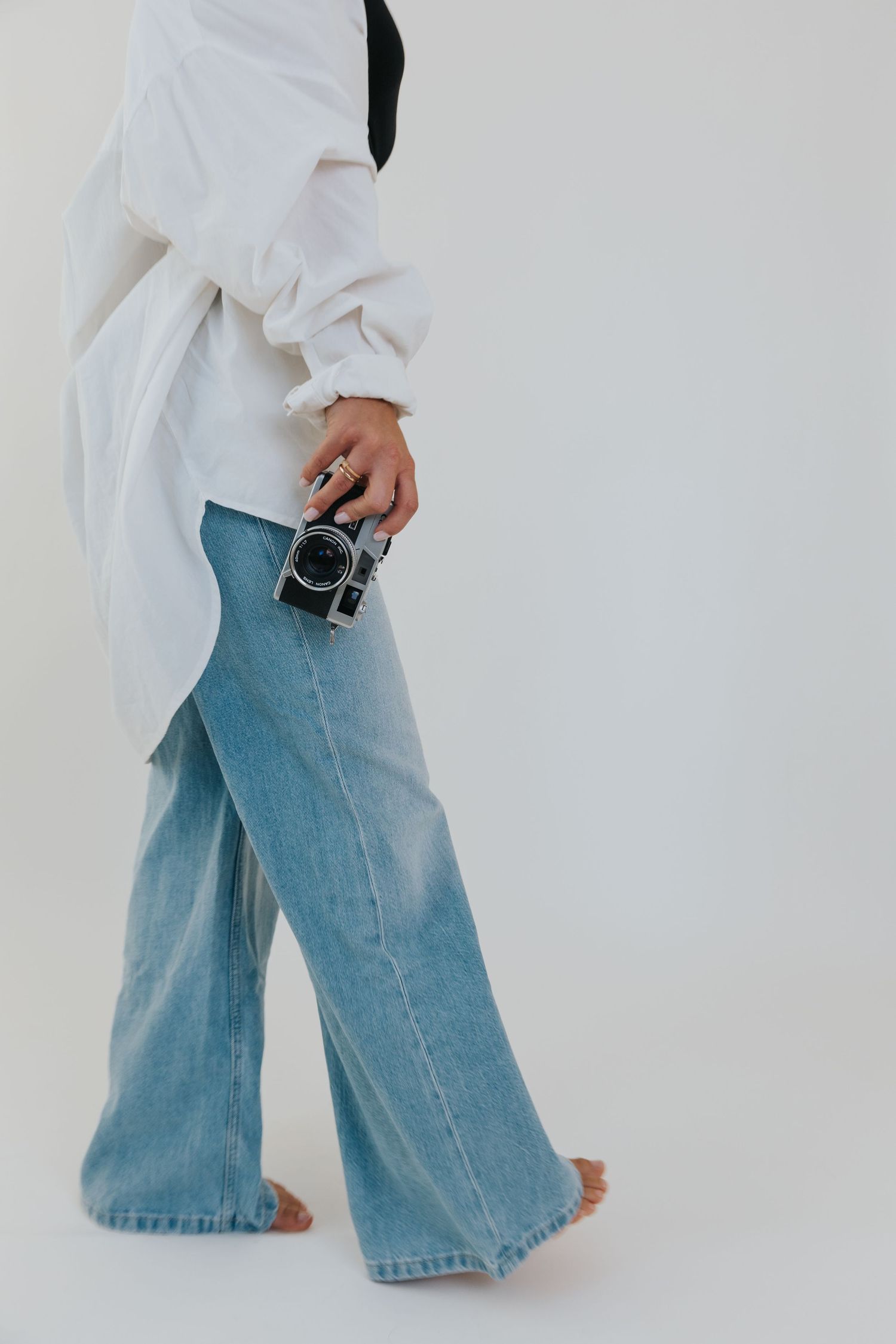 Close-up shots of light wash denim jeans and camera against white background.