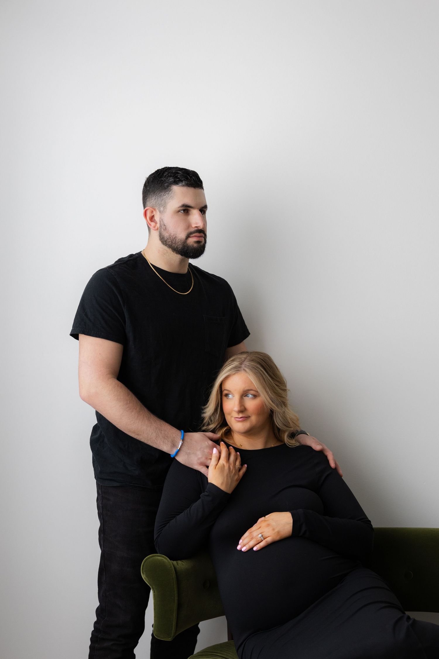 Romantic maternity photoshoot featuring couple in matching black outfits.