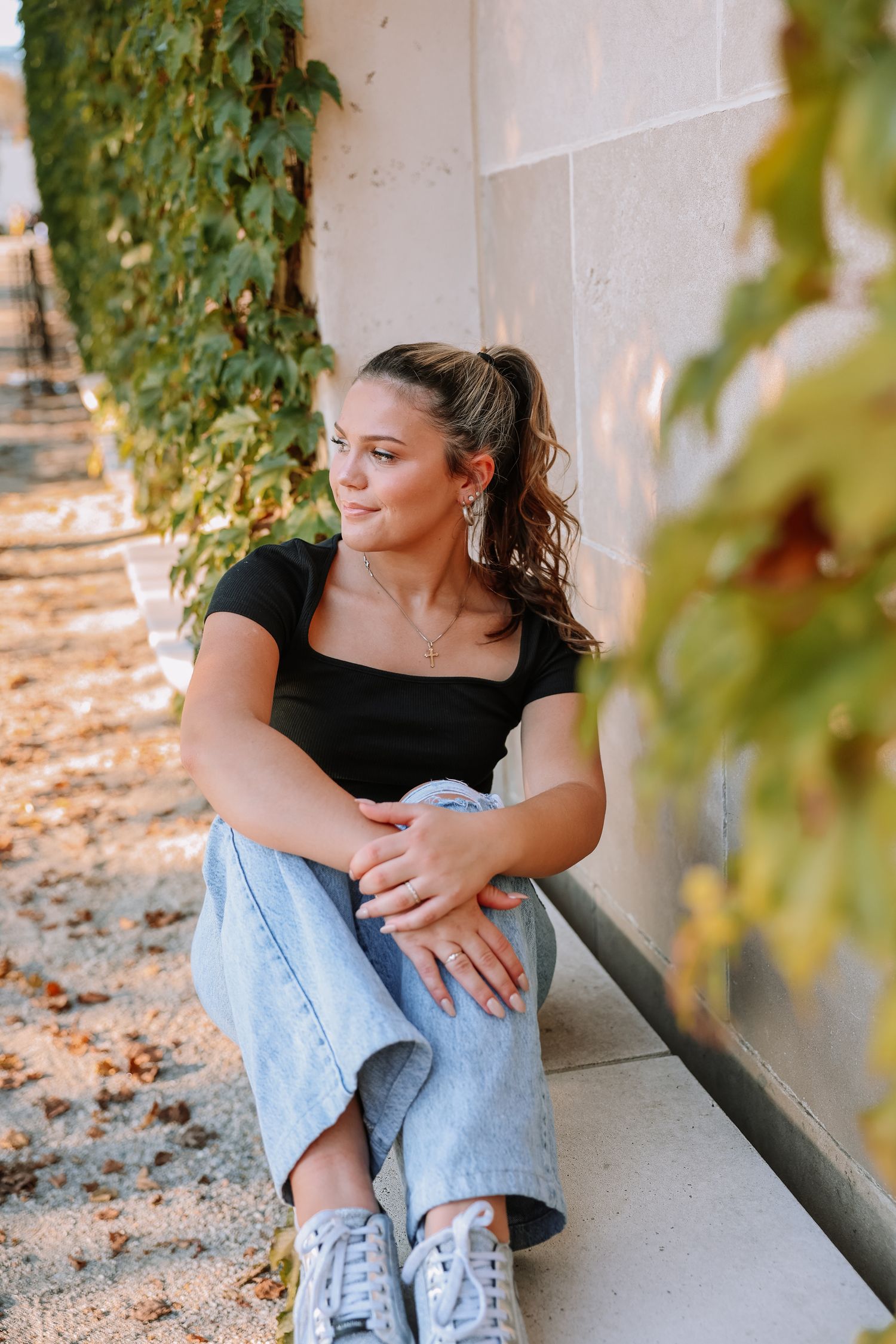 Relaxed poses in a covered walkway with climbing vines and natural light.
