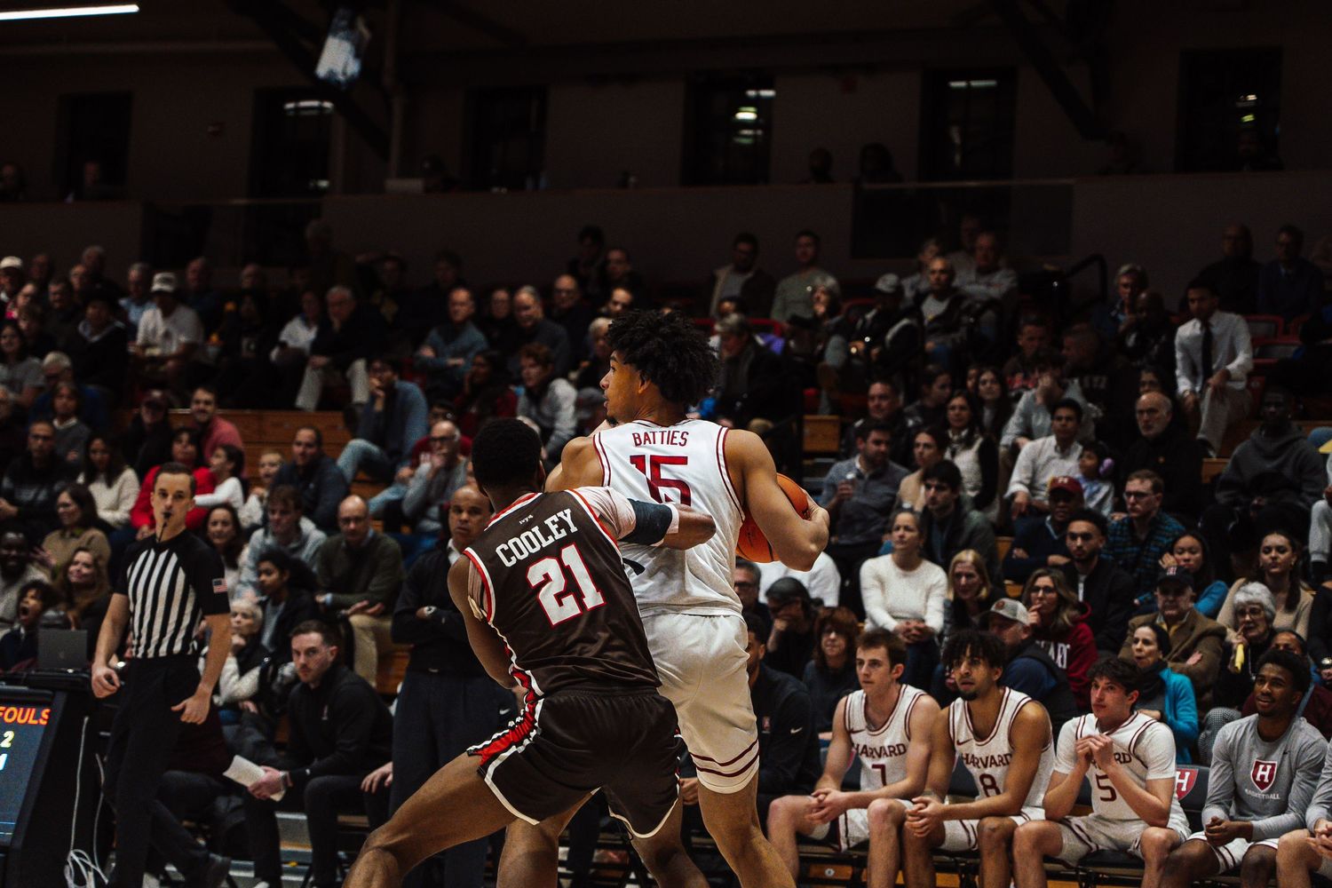 A basketball player defends the ball from an opponent.