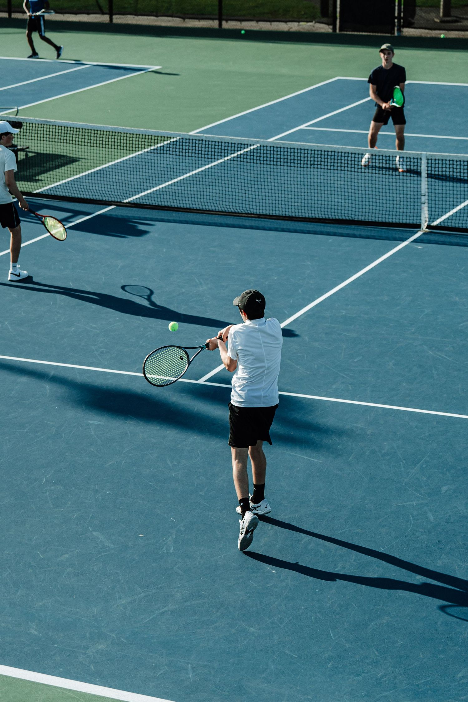 A tennis player returns a serve with an overhand hit.