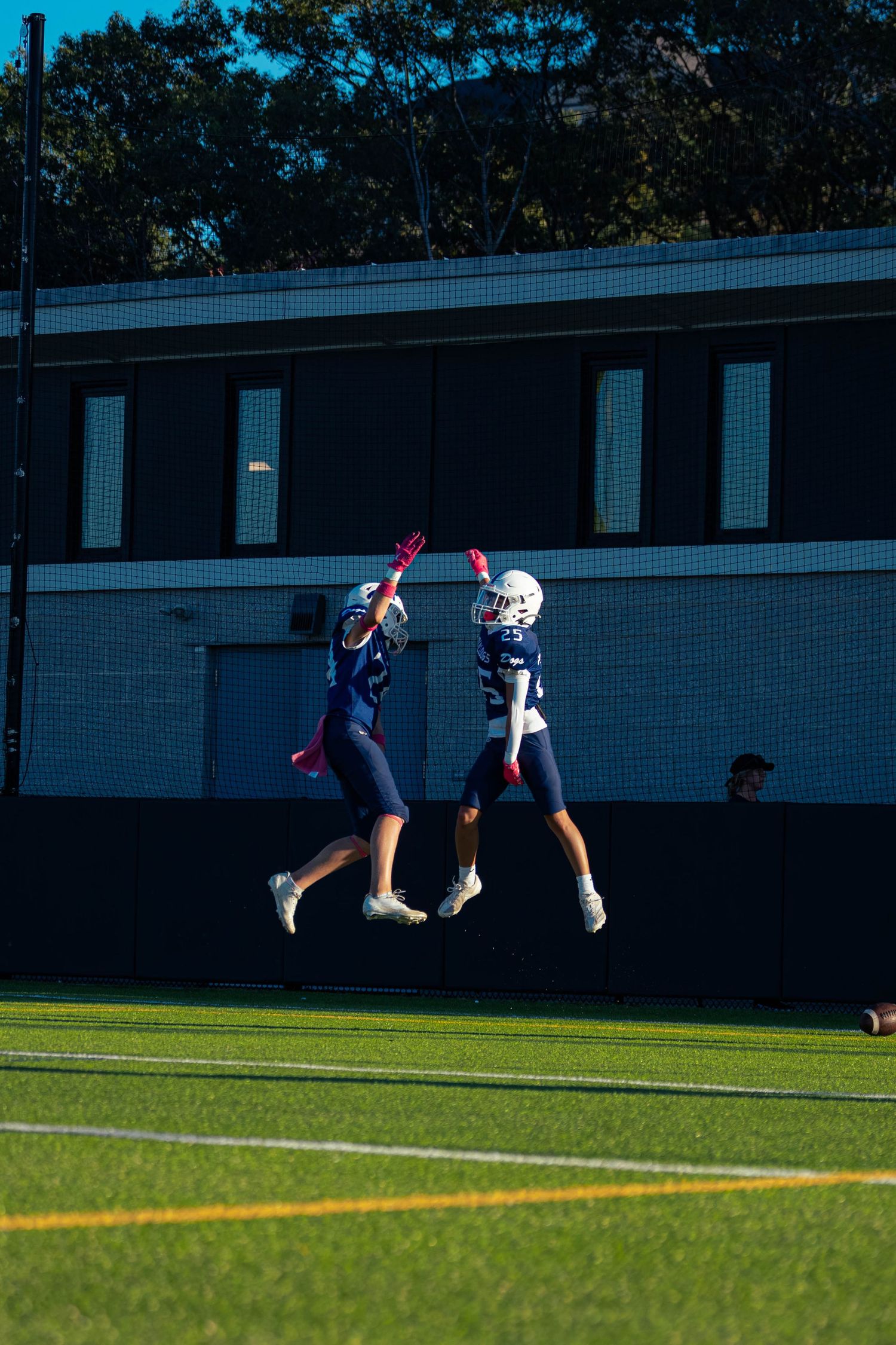 Two football players celebrate a touchdown.