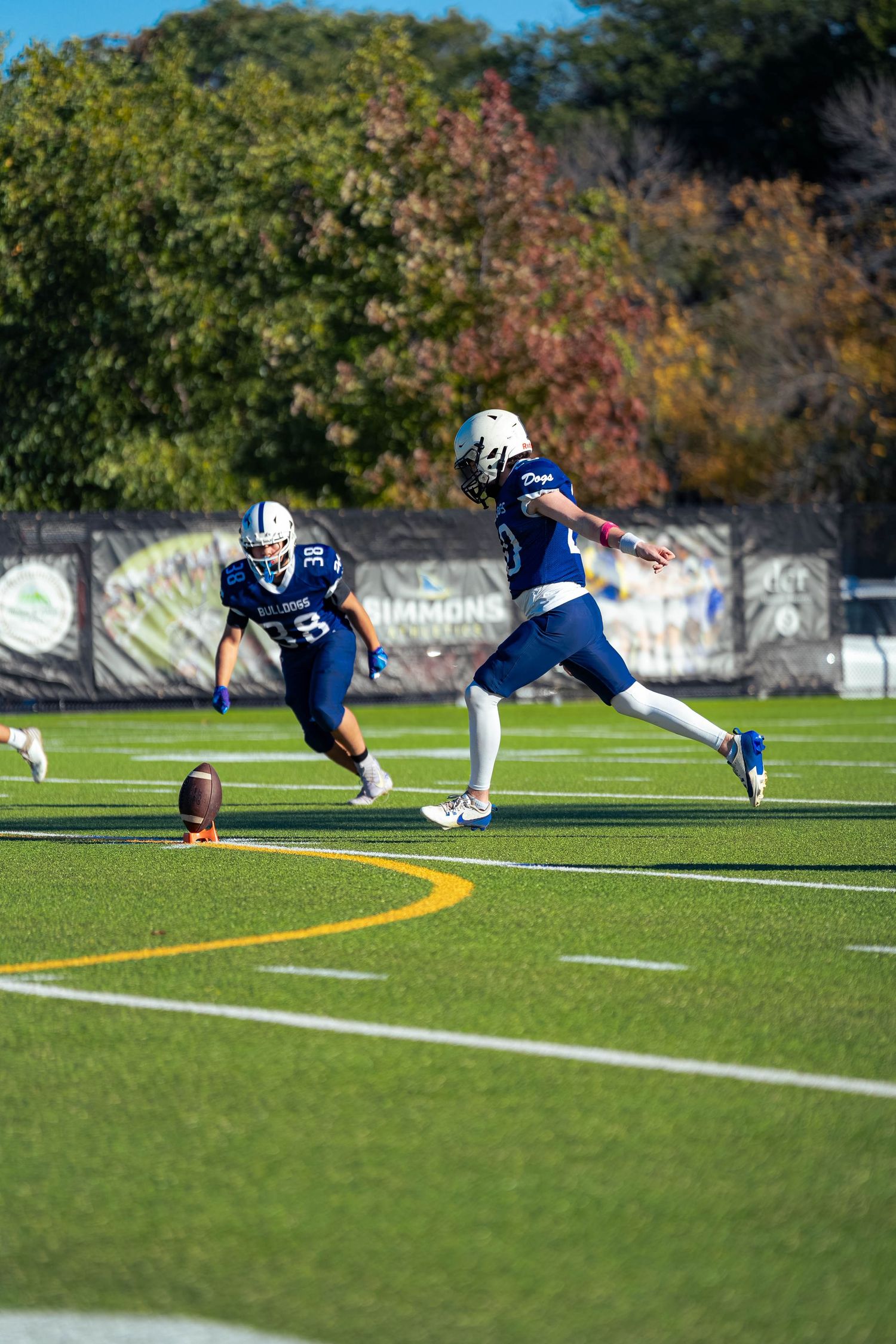 A football kicker charges up his kick mid-run.