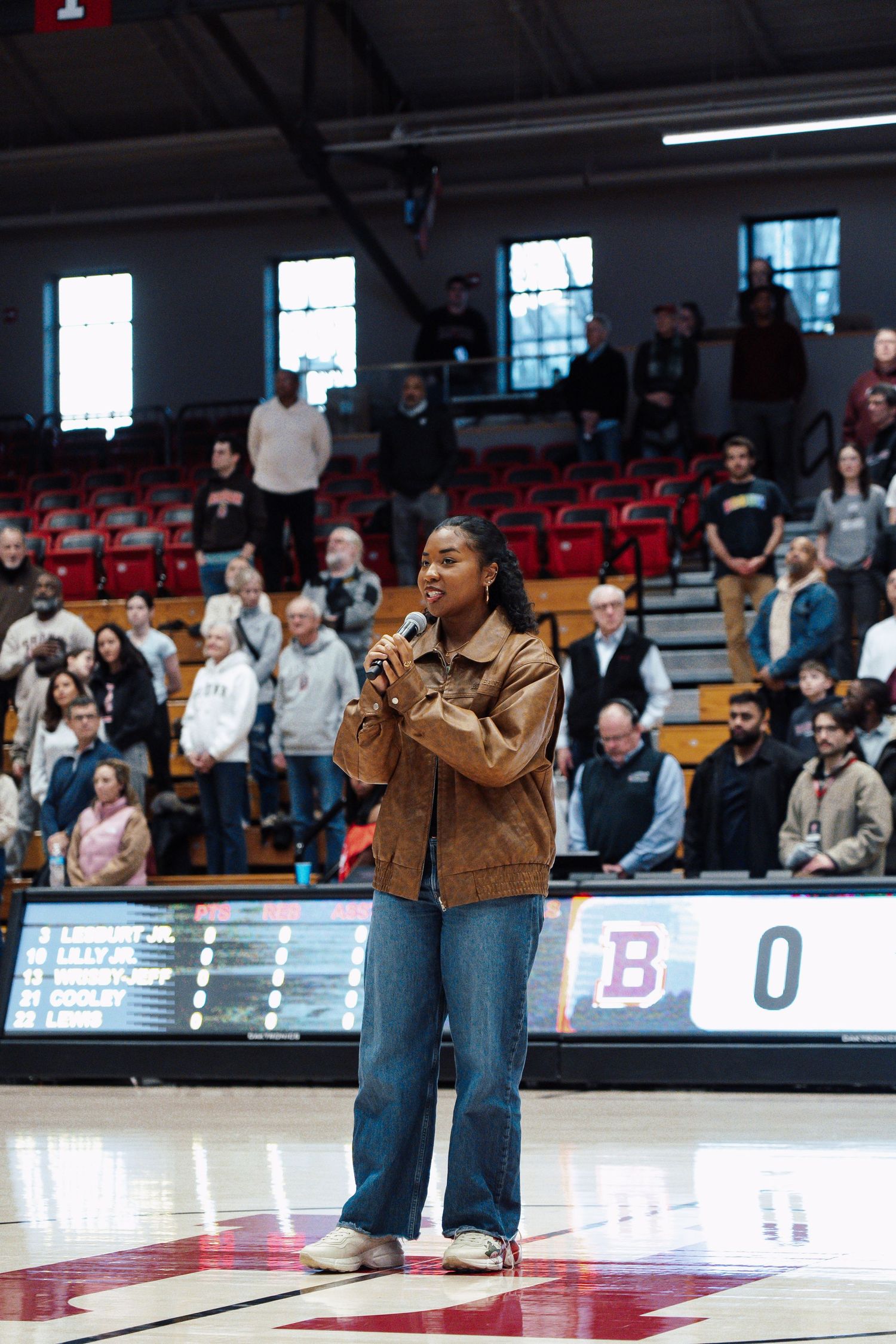 A singer sings the national anthem before a basketball game.