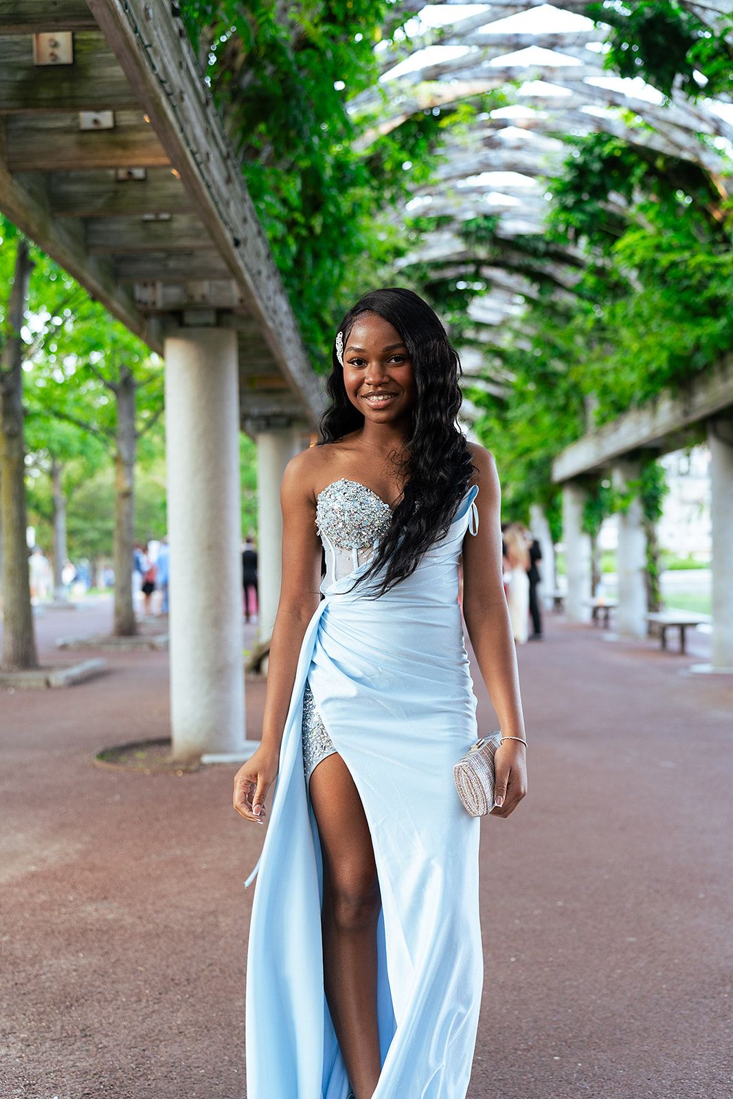 A girl smiles for the camera in her prom dress.