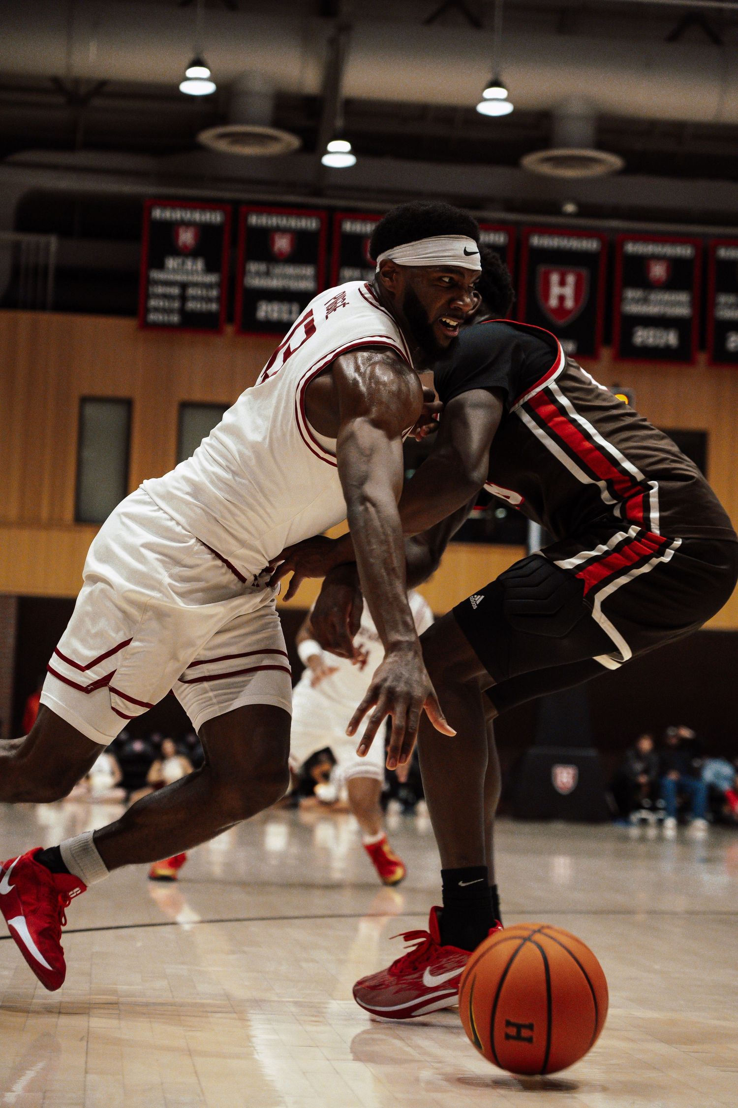 A Harvard basketball player narrowly avoids his opponent.
