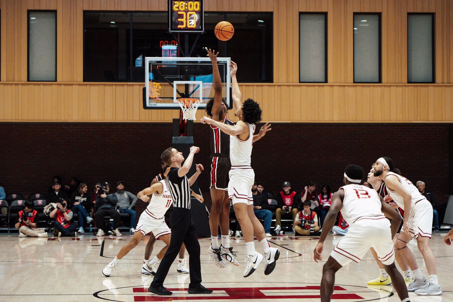 The starters reach for the ball during a basketball game.