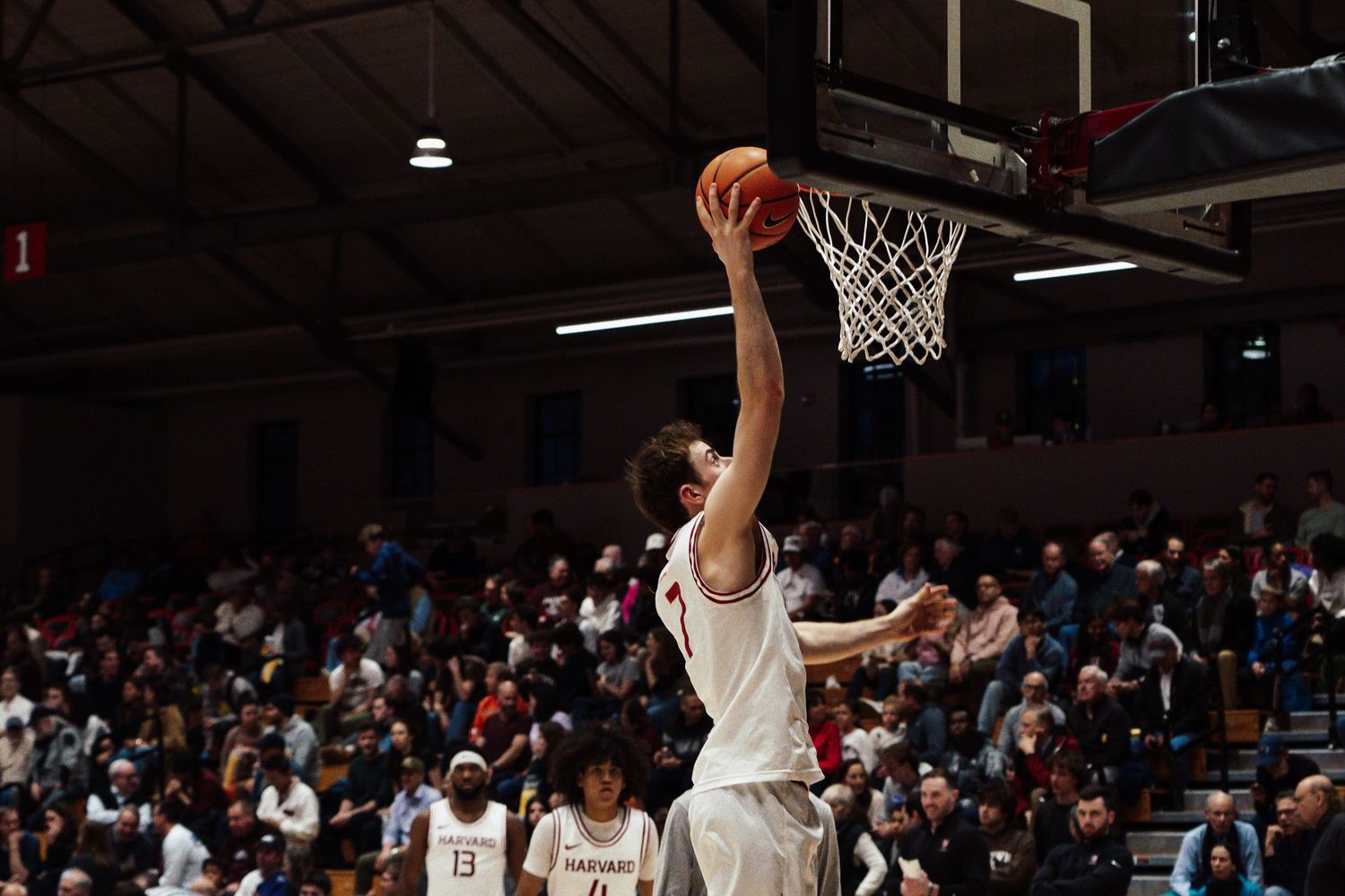 A basketball player dunks on his opponent.