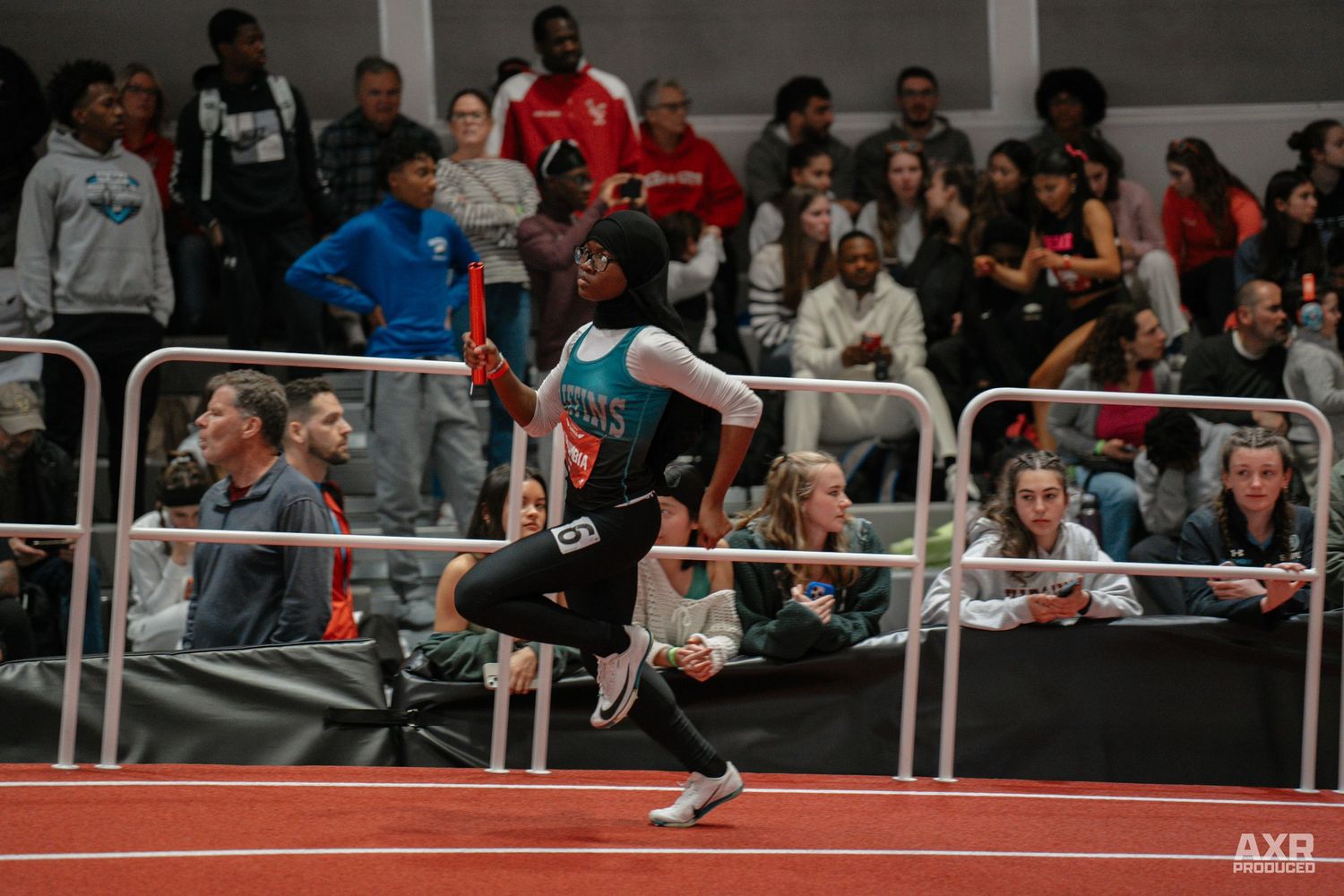 A girl dashes down the track with a crowd behind her