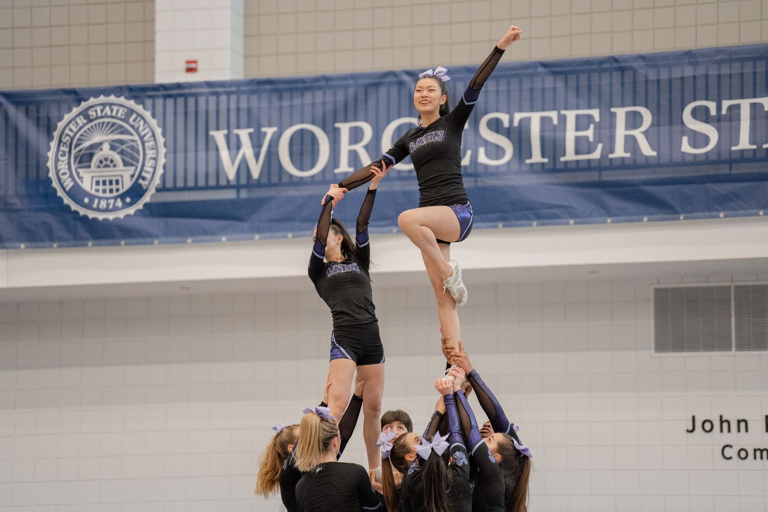 A cheer flier waves to the crowd in a stunt.
