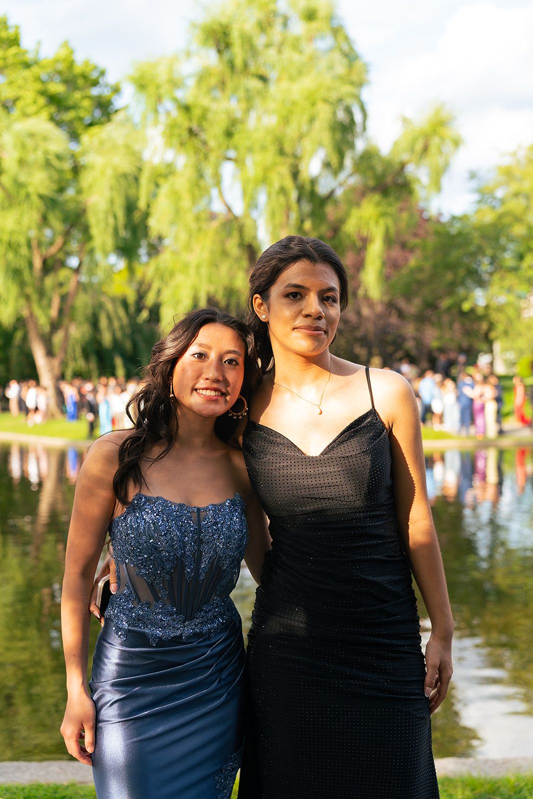 Two friends pose in front of the Swan Pond at Boston Public Garden.