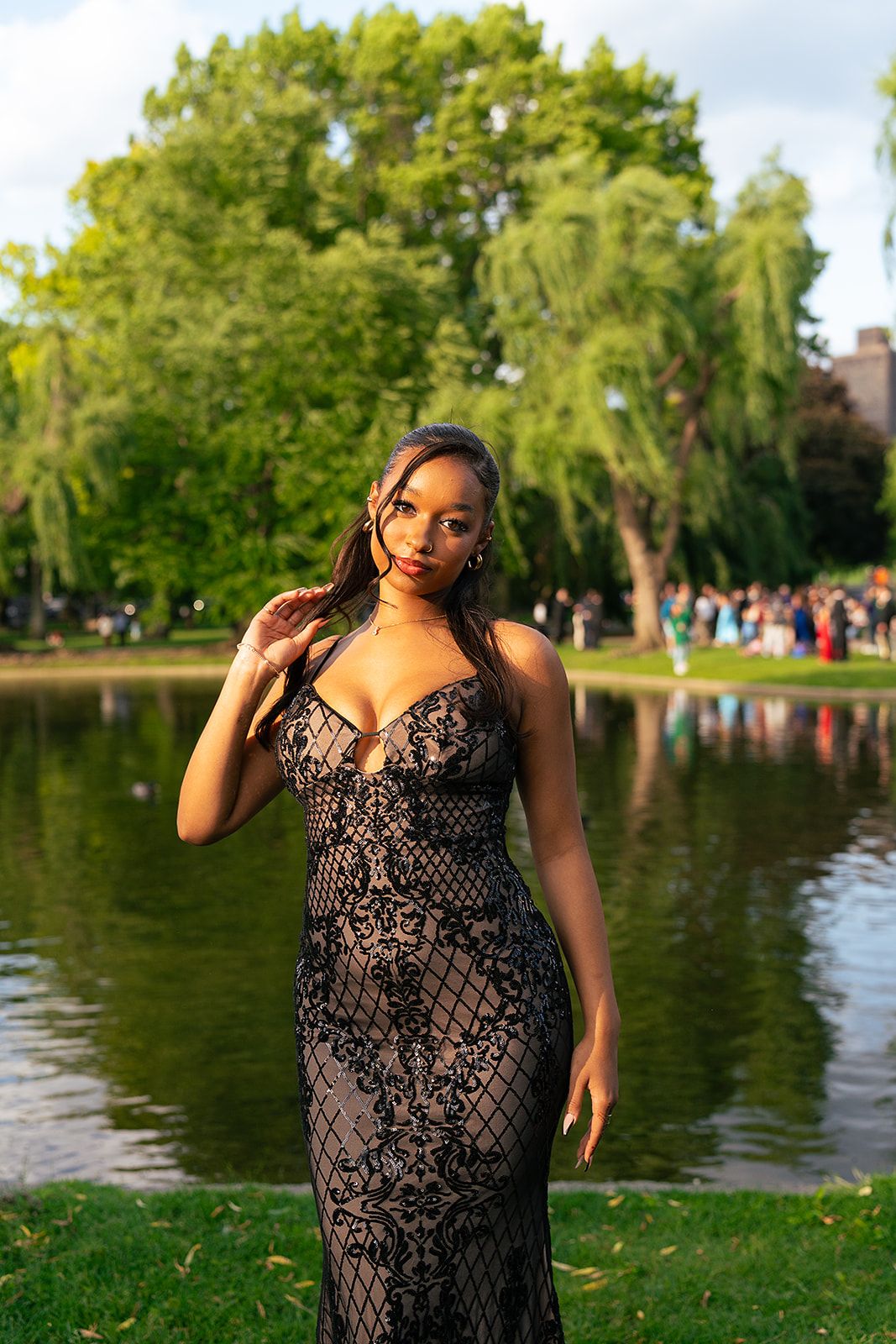 A girl poses in front of the Swan Pond at Boston Public Garden