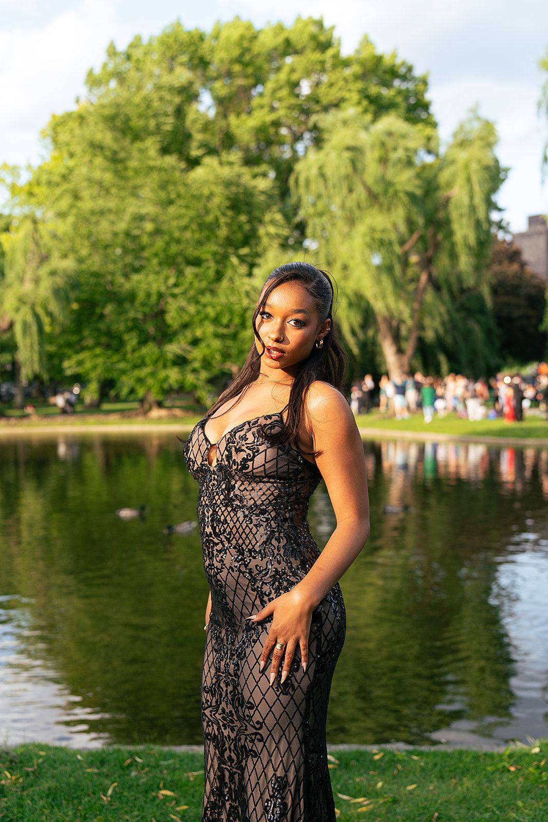 A girl poses in front of the Swan Pond at Boston Public Garden